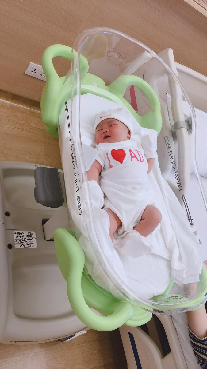 REVIEW ĐẺ TẠI BỆNH VIỆN QUỐC TẾ MỸ

Hôm nay nhân lúc em Xuka đang ngủ, mình kể lại quá trình đi sinh em ý cho các mẹ bầu tham khảo và có thêm sự lựa chọn nhé!🌸🌸🌸

1. CHUYỆN ĐI ĐẺ EM XUKA 👼👼👼
🎉Lần vượt cạn thứ hai của mình diễn ra khá bất ngờ, vì em bé đòi ra trước 10 ngày, khác với anh Tô quá dks đến cả 2 ngày mới chịu chui ra nên mẹ em vẫn chưa kịp chuẩn bị tinh thần. Thứ 7 đó, mẹ vẫn chăm chỉ đi làm với deadline cần hoàn thành trước khi nghỉ Tết, chiều tối về tranh thủ phụ bố em dọn nhà đón Tết, sau đó đi ăn SN chị Chích Bông và tất niên cuối năm nhà bác Xuyen Vu Ha
🎉Đến 11h pm mình và ox về nhà, lúc này anh hai đã ngủ lại nhà các bác vì hôm sau hai vợ chồng mình có lịch đi công tác SG lúc 4h sáng hôm sau, lúc đó mình xuất hiện cơn gò nhẹ, giống như mọi khi xuất hiện cơn gò giả, mình không mấy bận tâm đến nó và ung dung vào phòng nằm lướt fb 😁
🎉Lần đầu sinh Tô mình được báo trước bằng việc bong nút nhầy, và những cơn đau chuyển dạ kéo dài gần 30h đồng hồ anh hai mới chịu ra, nên lần này có phần chủ quan khi không có máu báo hay vỡ ối, cơn gò thì vẫn nằm trong tầm kiểm soát nên mình an tâm đi ngủ.
🎉Cho đến 11h30 đêm đó, các cơn gò xuất hiện ngày càng nhiều, liên tục thúc xuống dưới bụng dưới, tần suất 20’ một lần. Mình cuống lên kêu chồng, rồi thu xếp đi tắm gội sạch sẽ chuẩn bị lên đường (phần này là luật bất thành văn của các mẹ sắp lâm bồn, nên các bác đừng hỏi tại sao nhoé 😅). Anh chồng vui tính, còn cố động viên vợ: thôi em cố nhịn đi rồi 4h anh đưa em lên SG để họp báo cáo tổng Cty. Mẹ nào từng đau đẻ vào phát biểu cho chồng em sáng mắt ra chứ vợ đau đẻ mà kêu em nhịn thì em cũng thuaaaa 🤣🤣🤣... hâhhaa, lúc đó e cáu quát um lên rồi, kêu ổng ở nhà đi, tôi đi đẻ một mình. Thế là giời ko chịu đất thì đất phải chịu giời chứ biết sao giờ... 😎
🎊Hơn 12h mình bắt đầu xuất phát từ Vũng Tàu đi đến bệnh viện. Nói về bệnh viện đón em Xuka, thì lần này hai vc mình chọn bệnh viện quốc tế Mỹ (AIH) ở quận 2, lý do đó là bv quốc tế gần Vũng Tàu nhất ~ 90km (lúc đầu m chọn bv quốc tế Hạnh Phúc)
🚘Trên đường đi, các cơn gò liên tục và dồn dập: từ 15’ giảm dần còn 10’, 6’, 3’,.... cả quãng đường 90km mà mình đếm từng s, chưa kể hôm đó đội quân gia đình đưa mình đi viện, bác nào cũng say bí tỉ. Lúc tối ăn tất niên, bố Xuka với các bác dzô dzô nhiệt tình lắm :” nay tất niên năm cũ anh em uống hết mình nha “ vậy nên mị đau bụng lắm rồi mà không giám la, la lớn rồi nhỡ đâu lại lái không chuẩn 😊. Đành cắn răng mà cấu chồng vậy... (À chia sẻ thêm cho các bác là chở người đi cấp cứu là được xả trạm BOT, thông chốt trạm thu phí hết nha các bác 😂 em Xuka được thông chốt 4 trạm từ VT lên SG đó)

🎊Mình đến BV lúc 2h5’ sáng và được chuyển vào phòng cấp cứu. Lúc này mình đau và hét muốn banh cái BV 😂 bác sĩ khám và ôi thôi toang, ối vỡ tràn bờ đê, chuyển gấp sang phòng sanh, mình quằn quại đau, hỏi bs có chuyển mổ hay giảm đau bằng pp gây tê màng cứng được ko, vì lúc này mình đau quá rồi, nhưng bs từ chối vì em bé đã sắp ra đời, ko kịp làm các thủ thuật giảm đau 🤨 mị được hưởng trọn combo đau đẻ không thuốc tê 😆
❤️May mắn mình gặp bs Thuận và đội ngũ y tá, điều dưỡng trực hôm đó khích lệ tinh thần của mình rất nhiều, theo cảm nhận của mình là bs rất nhẹ nhàng, chuyên môn cao nên lúc sinh mình được hướng dẫn rất chi tiết cách rặn đẻ sao cho nhanh chóng, an toàn cho bé, giảm đau cho mẹ. Bác còn dặn dò cẩn thận, chú ý rặn theo hướng dẫn của bác không là mẹ mất sức. Sau 3 hơi rặn sâu thì em Xuka cất tiếng khóc đầu đời lúc 02h35’. Xuka được sinh thường và bất ngờ hơn là em nặng 3920g, vượt sức mong đợi của mình ( lúc này em mới chỉ hơn 38w) 😍
❤️Sau khi được cắt dây rốn, Xuka được skin to skin với mẹ và bú sữa non ngay sau đó. Cảm giác khi được ôm em ý vừa xúc động, vừa hạnh phúc, vừa “ đã” gì đâu 🥰🥰🥰

2. REVIEW BỆNH VIỆN QUỐC TẾ MỸ - QUẬN 2 - TPHCM 🏩🏩🏩
Mục này nhiều mẹ ở Vũng Tàu mình quan tâm nè vì ưu điểm là gần sịch Vũng Tàu luôn á, đi hết cao tốc là tới ~1,5h di chuyển, bệnh viện tuy mới đi vào hoạt động được hơn 1 năm thôi nhưng về đội ngũ y bác sĩ và chất lượng dịch vụ thì không chê được điểm nào, mình đánh giá 5/5* luôn, đi đẻ đúng như đi nghỉ dưỡng vậy đó, ai cũng nhỏ nhẹ từ bác sĩ, y tá đến nhân viên phục vụ phòng... 💕
🌸Lúc đầu mình chọn bv qt Hạnh Phúc ở Bình Dương, nhưng anh chồng nhất định không chịu vì lý do không muốn trên giấy khai sinh của con ghi nơi sinh là Bình Dương, trong khi con ở VTau nên nằng nặc chọn nơi sinh cho con hoặc ở TPHCM hoặc BRVT. Lý do trời ơi, nhưng ngẫm ra cũng thấy hợp lý nên em chuyển qua BV quốc tế Mỹ tại quận 2 luôn 😆

Cảm nhận đầu tiên khi đến BV AIH chính là cảm giác đang được ở trong một căn chung cư cao cấp, tất cả mọi thứ đều sạch tinh tươm, trang thiết bị hiện đại, từ phòng sinh đến phòng lưu viện, đúng chuẩn quốc tế 😍😍😍

🌸Mình chọn gói sinh thường, phòng sinh gia đình “4 trong1” tiêu chuẩn Mỹ, còn gọi là phòng LDRP ( chuyển dạ chờ sinh - sinh thường - hồi phục - theo dõi sau sinh. Cả gđ mình lưu trú tại một phòng duy nhất từ lúc vào viện đến khi ra viện
Mình sinh thường nên nằm lưu viện ~3 ngày, nếu sinh mổ thì 4 ngày.
🌸Mỗi ngày đều có bác sĩ khoa sản và bs khoa nhi đến khám cho mẹ và bé, các cô y tá điều dưỡng thường xuyên ghé động viên và hỏi han xem có cần hỗ trợ gì không?, có còn đau không? trong phòng và trong toilet đều có nút chuông khẩn cấp và chỉ 10s sau các cô y tá đã có mặt hỗ trợ cho mẹ và bé từ những việc nhỏ như: thay tã, dỗ bé, pha sữa hay súc rửa, tiệt trùng bình sữa,... lúc đầu mình cũng ngại, tâm lý sợ làm phiền, nhưng với thái độ siêu dịu dàng, dễ thương của các bạn ấy mình thực sự rất an tâm và hoàn toàn hài lòng với quyết định chọn sinh con BV AIH.
Chưa kể gặp bs giỏi, tâm lý thoải mái nên sau 2 tiếng hồi sức về phòng nội trú là mình có thể đi lại nhẹ nhàng và cho bé bú được rồi. Hôm sau cứ gọi là đi lại phà phà, cười phớ lớ luôn 🤣🤣🤣
🌸Mỗi ngày BV sẽ cung cấp cho mình 5 phần ăn đầy đủ dinh dưỡng, gồm 3 bữa chính và 2 bữa phụ. Mỗi buổi sáng là các bạn nhân viên mang menu hỏi xem mình muốn ăn gì để chuẩn bị, thực đơn thì đa dạng đủ các món Á, Âu, truyền thống, ... Đồ ăn với mình thì khá là ngon, trang trí đẹp mắt, lần nào ăn xong mình vẫn còn thèm 🤣🤣🤣

Thật chứ khi xuất viện ra về mình buồn thiu, chỉ muốn nằm viện hoài luôn vì sướng quá. Nói chung là mình và Gđ đã có những trải nghiệm sinh bạn Xuka trên cả tuyệt vời tại Bệnh viện quốc tế Mỹ AIH😝

Đi đẻ mà như đi nghỉ dưỡng tại ks 5* vậy đó. Mẹ chỉ cần ... đẻ thôi, mọi vấn đề khác đã có đội ngũ bác sĩ, điều dưỡng viên lo hết rồi. Các cô chú siêu có tâm, động viên, hỗ trợ từng li từng tí để mẹ được tự tin và thoải mái trong suốt quá trình vượt cạn. Không biết phải nói cảm ơn sao cho đủ ❤️❤️❤️

🎁5 tiêu chí khi chọn đi sinh tại Bệnh viện Quốc tế Mỹ:
1. Chuyên môn: khi chọn nơi sanh thì tiêu chí an toàn cho cả mẹ và con cần được đặt ra hàng đầu. Do vậy các mẹ nên chọn bệnh viện có chất lượng chuyên môn tốt, các quy trình, quy chuẩn chặt chẽ tránh những rủi ro có thể xảy ra.
- Về chuyên môn: Bệnh viện Quốc tế Mỹ (AIH) là bệnh viện đầu tiên tại Việt Nam có sự hợp tác chuyên môn với Johns Hopkins Medicine International (JHI), một trong những hệ thống chăm sóc sức khỏe hàng đầu tại Mỹ. Qua đó AIH đã nâng cao các tiêu chuẩn chăm sóc sức khỏe tại Việt Nam.
- Về quy trình, quy chuẩn: Với định hướng chất lượng đạt chuẩn JCI ngay từ những ngày đầu xây dựng, trong quá trình quản lý và vận hành, bệnh viện Quốc tế Mỹ AIH đã có những quy trình quy chuẩn nhằm đảm bảo an toàn cho mẹ và bé, thậm chí cả thân nhân thăm nuôi nhằm hạn chế những rủi ro, sai sót trong quá trình khám, điều trị.

2. Cơ sở vật chất, trang thiết bị: Bác sĩ giỏi nhưng cơ sở vật chất kém, thiếu thốn cũng khó cho cuộc vượt cạn an toàn. Bệnh viện Quốc tế Mỹ xây dựng ngay từ đầu với tiêu chuẩn của Mỹ ngay từ thiết kế cơ sở hạ tầng đến các trang thiết bị máy móc.

3. Dịch vụ: chăm sóc giúp các mẹ cảm thay an tâm vượt cạn. Đội ngũ chăm sóc khách hàng của Bệnh viện Quốc tế Mỹ được đào tạo bài bản, làm việc rất tận tâm, luôn hỗ trợ các mẹ bầu 1 cách tận tình. Thậm chí đội ngũ chăm sóc khách hàng còn luôn hỗ trợ nhắc hẹn và sắp xếp lịch hẹn cho các Bác sĩ làm việc 1 cách khoa học và hiệu quả.

4. Chi phí: Với những tiêu chuẩn trên thì AIH có thể nói là Bệnh viện đạt chuẩn quốc tế có giá hợp lý nhất hiện nay.

5. Vị trí địa lý: Nơi sinh thuận tiện cho việc di chuyển, đặc biệt những tình huống cấp cứu. AIH đặt ngay trung tâm Quận 2, đi đâu cũng gần, thuận tiện về giao thông, hiếm khi xảy ra kẹt xe.

Các mẹ đang có bầu, hoặc có kế hoạch sinh con đừng lo lắng gì hết nhé! Làm mẹ là thiên chức kỳ diệu mà tự nhiên trao tặng cho phụ nữ chúng mình, các mẹ cứ bình tĩnh và yên tâm, chuẩn bị tâm lý vững vàng và chọn được nơi vượt cạn như ý thì cơn đau đẻ sẽ qua mau như mẹ Xuka thôi 💕
Chúc các mẹ có thai kỳ khoẻ mạnh và chọn được nơi sinh ưng ý nhé ❤️

Cre: Sora Chan