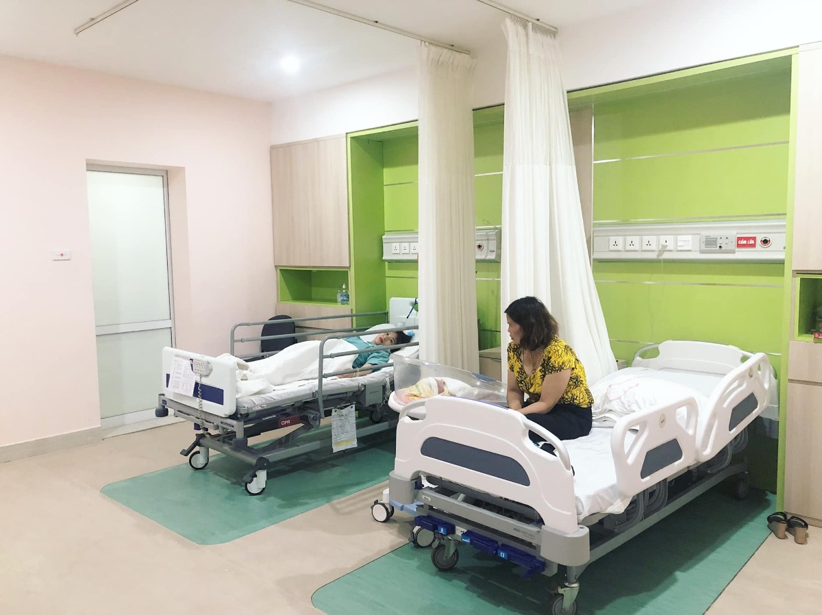 REVIEW ĐẺ TẠI BỆNH VIỆN BẢO SƠN

Vậy là đã 1 tháng trôi qua, kể từ ngày 2 mẹ con mình vượt cạn cùng các Y Bác Sỹ tại Bệnh viện Bảo Sơn.🌼
Khi vào nhóm chắc chắn cũng nhiều ng muốn tìm hiểu về dvu ở BS như e lúc đang tìm hiểu nên e sẽ chia sẻ chút vs mng.
 Hôm nay có time rảnh rỗi để ngồi viết chút review cho chị e tham khảo!
- Đứa đầu e chọn Phụ Sản HN vì tuyến đầu ngành cho yên tâm. E đẻ dịch vụ mà nghĩ đến h vẫn sợ, quá đông ạ, mở hết 10p r mà con e lại quậy quá nên bsy chỉ định mổ. Mổ xong 2 ngày thì về, chuyên môn khỏi phải bàn nhg dịch vụ thì chắc ai đi rồi sẽ hiểu.
- Đứa thứ 2 e quyết định mổ chủ động bvien tư. Vì đúng đợt dịch, phụ sản sẽ rất đông e cũng lo, mà cũng muốn vượt cạn dịch vụ tốt xíu. Sau khi tìm hiểu thì quyết định mổ lần 2 tại Bệnh Viện Đa Khoa Bảo Sơn.
👐🏻 Lần này, đi đẻ nhàn quá các bác ạ! E đến khám tuần thứ 36, thủ tục lm hồ sơ có nhân viên tư vấn lm hết, mih cũng k phải lz. Khám xét nghiệm trước sinh e thấy kỹ, nhiệt tình, có bạn tư vấn viên đưa đi khám từng khâu rất nhanh chóng, ko lo bỡ ngỡ. Khám xong sang ăn sáng tại Bảo Sơn Hotel rồi quay về lấy kết quả.
- Có những mức giá theo tuần đky tư lúc mới bầu cho tới lúc đẻ. E chọn gói 38w đẻ mổ lần 2. Đúng đợt này đang đc giảm giá. Đẻ xong lú quá e hay quên, mà cũng ck trả viện phí nên k nhớ chi tiết.
- Đi đẻ đúng nhàn tênh, các bác chỉ cần mang bộ quần áo của mẹ và bé hôm xuất viện thôi nhé. Đồ ở bệnh viện cbi cho đầy đủ hết rồi.
- Tiếp đến là hôm đi mổ chủ động. Cứ thế đi đến lên thẳng vào lm các bước trước mổ, xong xuôi chuyển vào phòng mổ. Lần này, cảm giác còn sợ hơn lần 1. Lần đầu đau đẻ e ko khóc đâu, bsy bảo mổ cái nước mắt chảy ròng ròng, cơ thể yếu ớt tn mổ xong tiếp xúc da với con xong ngất luôn nên thiếp đi khoảng 2,3 tiếng tỉnh dậy rồi mới đc chuyển về hậu phẫu. Nên mổ l2 e vẫn sợ lắm. Mà các bác sỹ, hộ sinh cứ cổ vũ, khích lệ tinh thần nên e cũng bớt lo. Nói chuyện đc vài câu thì thấy cu con oe oe ra chào mẹ roi. Lúc này cả ê kíp mổ lại tiếp tục nchuyen vs e rất vui và rôm rả. Lần mổ 2 này e ko ngất cơ mà cũng bị nôn 2 lần ở phòng hậu phẫu, xong phải tiêm chống nôn ms hết. Nchug cả 2 lần mổ e đều bị tác dụng của gây tê tuỷ sống.
- Chuyển về phòng thì e book phòng up lên phòng riêng là 1tr4/ngày. E ở viện 4 ngày.
Gói mình đky ở viện là phòng sẽ ở 2 sản phụ, e up lên thì ở 1 mình nên phát sinh thêm khoản này. Ở phòng thường thì có đủ 4 bữa cho sản phụ và 1 bữa sáng cho ng nhà sang khách sạn ăn. E up lên phòng dịch vụ thì cả ng nhà cũng đc mang 3 bữa tại phòng và phiếu ăn sáng bên khách sạn.
- Về phòng sau sinh, bác sỹ Cốc ( mổ chính) cho mình về hỏi han rất chu đáo và bác tiêm mũi giảm đau sau sinh cho mình cũng xuống hỏi han liên tục xem có đau ko, rồi kiểm tra ống giảm đau thg xuyên.
+ Đêm đầu tiên sau khi mổ xong các y bác sỹ vào hỏi han thường xuyên, cứ 1,2 tiếng lại có điều dưỡng vào ktra, thay dịch, tiêm kháng sinh. 
+ Hết giảm đau 48h lúc này e đau quá, thì mỗi ngày đc đặt 2 viên giảm đau nữa ko thì chắc xỉu qá.(mổ l2 đau hơn l1 gấp trăm lần ce ạ 🤣)
+ Tối có điều dưỡng trực phòng kế bên nếu cần gì cứ gọi họ sẽ thay bỉm, pha sữa,.... cho. Nhg mẹ vs ck e làm hết roi cũng ko gọi. Chỉ lúc nào e đau ms gọi, nhg tối họ cũng thi thoảng vào ktra rồi.
+ Bị tắc tia sữa lúc nửa đêm gọi điều dưỡng sang massage tay cho ko thì chắc hôm sau e là e bị nặng lun mất.
+ Dịch vụ tốt quá, nhiều sự quan tâm quá nên e ko nhớ hết mà kể chi tiết với mọi ng luôn. Nhiệt tình từ lao công vào dọn vệ sinh ngày 2 lần rất cẩn thận và niềm nở cho đến nhân viên bên khách sạn mang đồ ăn sang cũng rất nhiệt tình. 
+ Đồ ăn ngon, thay đổi menu mỗi ngày cho sản phụ lưah chọn đa dạng, ko bị ngán.
- Ngày nào bác sỹ cũng qua hỏi han. Hôm cuối xuất viện ra thanh toán thêm những khoản phát sinh và lấy giấy tờ rất nhanh.
- Bvien còn đặt thuốc đây dịch cho ra nhanh nên ve nhà e chỉ còn xíu dịch vài hôm là sạch, chứ ko như lần đầu về cả tháng ms sạch.
- Ngày nào cũng tiêm co dạ con nên sau mấy hôm ở viện về bụng e xẹp lép luôn, chứ ko như lần đầu về bung như cái rổ, da con co mấy tháng mới nhỏ lại.
- Chiếu tia laser giúp khô vết mổ nhanh. Tvia vết mổ đẹp lm ạ.
- Bệnh viện tặng quà sau sinh. Mẹ và bé sẽ đc care trong vòng 1 thánh sau sinh có vấn đề gì cứ xuống viện ktra ạ. Bsi Thắm nổi tiếng chữa tắc tia sữa tại bvien nói cứ tắc là xg gặp bác ko cần phải đi đâu chữa cả.
- À! Và khoản đo chỉ số BMI là e thích nhất. Bác Sỹ lên thực đơn bữa ăn dinh dưỡng đảm bảo sữa cho con mà mẹ lại về cân nặng lý tưởng với chiều cao.
+Trước bầu  e 53kg( vì đẻ đứa đầu xog khó giảm về dáng lúc con gái qá) lên bàn đẻ 69kg. 
Đẻ xong hôm về nhà cân là 62kg, Sau 10 ngày cân lại h còn 58kg. Đấy là e còn thèm quá nên ăn dư chỉ tiêu chút xíu, nếu ko chắc giảm nhanh nữa. Bác Sỹ đg lên chỉ tiêu cho e xg 48. Hy vọng thành công hihi 😋
- Bệnh viện còn tặng gói chụp ảnh newborn cho bé nữa ạ.
❤️❤️❤️ Nói chung e rất hài lòng về mọi dịch vụ ở bệnh viện. Tính ra e thấy rẻ chứ ko hề đắt chút nào so với chất lượng nhận đc.
Riêng tiền phòng ở chất lượng, thuốc thang chu đáo, mọi thứ bvien lo tất chi việc đi ng ko. Còn lần đầu e đi đẻ dịch vụ mà nghĩ thấy ngán thật sự.
💸Đợt này đang đc giảm giá khoảng 10triệu nên xong tất e hết khoảng 35tr.
Các chị cứ ib hỏi e khỏi phải lăn tăn ạ.
À mổ đắt hơn chứ đẻ thường thì rẻ 1 nửa đấy ạ. Đẻ thường còn ko phải mất 3trieu mũi giảm đau 48h sau mổ nữa.
👉🏻👉🏻👉🏻Đây là chút chia sẻ của e về quá trình đi đẻ, và chút review về Bệnh viện đa khoa Bảo Sơn cho chị e tham khảo ạ. Mong giúp ích đc cho chị e.