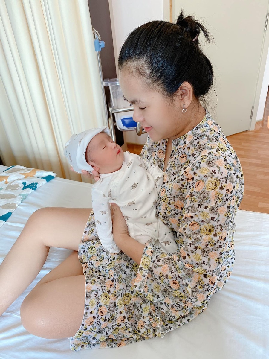 REVIEW SINH TẠI QUỐC TẾ CITY

Dạo này thấy có nhiều mom hỏi Cih nên mình cũng xin phép được review sơ sơ chuyến đi đẻ của mình.
Mình khám thai định kỳ ở Sih và tính sinh ở Sih luôn (m đã có 1 bài review khá dài về khám thai ở Sih), nhưng vì một số lý do mà vào phút gần chót 2vc quyết lại sẽ chọn Cih để đẻ.
38w mình khám thử tại Cih thì được hỏi luôn có sinh ở đây không để họ làm hồ sơ sinh, chi phí khám và siêu âm tầm 1tr + làm các xét nghiệm trước sinh hơn 4tr, tổng thiệt hại hơn 5tr.
39w mình tái khám theo lịch và hẹn bác sĩ ngày giờ mổ, được nhiều người mách bác Xuyến trưởng khoa nên m cũng theo bác. Bác rất nhẹ nhàng, dễ thương, nhiệt tình lắm ạ. M muốn mổ vào 15h bác ok ngay và dặn dò m sáng 7h ăn sáng, 8h nhập viện từ đó không được ăn uống gì.
39w4d mình vào viện làm các thủ tục, phòng ở đây tính tiền từ 12h trưa nhưng bv cho m nhận phòng luôn không phải đợi tới 12h, làm thủ tục nhập viện xong m được điều dưỡng cho đo tim thai rồi dẫn lên nhận phòng tầm 9h hơn. Sau đó các cô hộ lý vào phát đồ, hướng dẫn sử dụng phòng ốc, cần gì bấm chuông gọi, trong toilet cũng có chuông nếu chóng mặt chỉ cần bấm là có người vô đỡ. Bv có cho 1 bịch bỉm nhỏ Bobby, 1 bịch bvs Mama, 1 túi quần lót giấy, mấy mom có thể chuẩn bị thêm nếu sợ thiếu nhất là bỉm không đủ đâu nhé! Có bình thuỷ đựng nước nóng để cho mẹ uống, mỗi ngày phát 1c nước khoáng 1L nếu uống không đủ có chỗ hứng nước thêm vô. Đặc biệt cho đăng ký được 2 người ở lại dù mình đẻ phải mùa dịch cao điểm các bv khác đều được chỉ 1 người chăm mà mình có mẹ và bà vú. Phòng m đăng ký là phòng đơn tiêu chuẩn giá 2tr6/ngày (nếu ai không ăn là 2tr3). Bình sữa của bé thì phải gửi ở phòng các cô điều dưỡng tiệt trùng và pha chứ họ không cho m pha ạ. Nên đem theo vài cái bình để phòng các cô chưa tiệt trùng kịp mà em bé đòi ăn thì còn có mà pha ngay. Như bé nhà mình đẻ ra đã háu ăn, chưa có sữa kịp là nó gào lên rất kinh.
Kể tiếp chuyện đi đẻ, sau khi được phát đồ, hướng dẫn phòng ốc...thì m được kêu đi tắm được cạo vùng kín rồi đặt đường truyền nước, đo cơn gò tim thai em bé và nằm chờ tới 14h30 sẽ được đẩy đi mổ.
Ở Cih mổ được cho người nhà vào nhưng chồng mình sợ cảnh mổ xẻ không dám vào 🤣. 
14h30 mình được đẩy đi, xà quần tới 15h17 mới chính thức vô phòng mổ, lúc này bác Xuyến chưa tới, ekip mổ chuẩn bị mọi thứ sẵn sàng, rất đông các bạn trẻ trẻ không à, nam nữ có đủ, có 1 bạn phụ trách nhiệm vụ giải thích hay sao á lúc nào cũng đứng trước đầu mình giải thích các bước nói chuyện rất nhẹ nhàng dễ thương, là 1 bạn nam. 
Tới khúc gây tê cũng không đáng sợ mấy, như tiêm ngừa bình thường thôi, tiêm xong tê tê khá là nhanh, cái màn che căng lên, ở dưới mần gì không biết luôn 🤣, hai tay dạng ra 2 bên, thuốc tê càng ngấm m bị tác dụng phụ là run, không lạnh lắm mà run cầm cập luôn các mom à, các bạn ekip cứ hỏi m có lạnh không, có máy sưởi thổi vô trong lúc mổ nhưng m chỉ thấy run, bạn nam đứng trên đầu mình kêu mình hít sâu thở đều, hỏi hang m liên tục. 
Tiêm được chút xíu bác Xuyến vô mổ cho m, chỉ thấy cái bụng bị lắc qua lắc lại, không cảm nhận được gì, bạn ekip nam đứng trên đầu vẫn liên tục trấn an, giải thích, hướng dẫn hít thở thấy cưng lắm. 
Được chút xíu xiu nghe bác sĩ nói ra rồi ra rồi m mới biết là mổ rồi chứ trong lúc mổ chỉ thấy bụng bị lắc qua lại. Em bé ra mà chưa nghe khóc luôn, m mới hỏi "sao chưa nghe em bé khóc", bác sĩ kêu "khóc không nên lời luôn", rồi nghe bác sĩ nói thêm "khóc đi, khóc đi", sau đó là tiếng oe oe của con vang lên, nước mắt mình cũng chảy theo, bạn ekip nam trên đầu m lại tiếp tục động viên, kêu m không được khóc, nói chuyện nhẹ nhàng dễ thương lắm luôn. (M không biết mấy bạn trong ekip mổ phụ bác sĩ gọi bằng danh xưng gì nên tạm gọi vậy nha)
Em bé bắt ra xong được kề da với mẹ, ẻm khóc oe oe mà đặt lên người mẹ cái nằm im ru, cảm xúc thiên liêng lắm luôn chắc mấy mom trải qua rồi ai cũng hiểu. 
Kề da được chừng 5-10ph gì à, em bé được mang đi, lúc này thì mẹ được khâu vết mổ, chuyện em bé nghe ba nó kể tiếp. Ẻm được đem ra người nhà chỉ được cho ba đi theo xem, ẻm được đo nhịp tim rồi để vô cái máy làm ấm... nghe ba ẻm kể sơ sơ vậy thôi, xong kiểm tra một lúc thì em bé đưa về phòng trước trong khi mẹ nằm hồi sức. 
Quay lại kể chiện mẹ nằm hồi sức, khâu và lau chùi xong xui người ta mới bỏ cái màn che ra thành thử từ lúc gây tê xong ai mần gì mần mẹ không hay biết chi tới lúc xong hết. Mẹ được đẩy ra bên ngoài nằm hồi sức theo dõi tầm 2 tiếng. Tác dụng phụ của thuốc gây tê vẫn làm mình run cầm cập mà cơ địa m không bị lạnh nha, rồi đột nhiên cơn buồn nôn ập tới, sau khi nôn mấy phát không ra được gì thì hết run cũng hết buồn nôn luôn, lúc nôn có người cầm thau kê vô kế bên cho m nôn ạ. Thuốc tê dần dần tan, người m cũng càng lúc càng nóng lên, m phải đẩy mền xuống một nửa chỉ đắp cái áo bệnh viện, m còn nói nóng quá mấy bạn điều dưỡng phải giải thích máy lạnh trung tâm hông chỉnh cho m mát thêm được 🤣. Cái này là do cơ địa nha vì m nằm được lúc có một mom khác cũng mổ ra nằm hồi sức kế bên lạnh cầm cập phải chạy máy sưởi. 
Xong 2 tiếng m được đẩy về phòng với em bé, không được nằm cao đầu tới sáng nên hơi khó chịu tí, vết mổ đau nhưng vẫn trong sức chịu đựng của m được, ráng nằm nghiêng qua cho em bé bú sữa non đầu đời. Nghe nói ẻm khóc nãy giờ đòi bú, bú được tí sữa non ẻm phê phê im ru, may sao ở đây mổ hồi sức có 2 tiếng à, chứ bên Sih tư vấn m hồi sức 6 tiếng lận nè.
Tối đó đau vết mổ nhưng m vẫn nghiêng qua lại cho bé bú mỗi lần bé e e lên. Sáng hôm sau m được rút ống thông tiểu và được dặn dò tập đi, mọi thứ thấy cũng trong sức chịu đựng được, không đau thấu trời xanh như nhiều mom diễn tả đẻ mổ, với thuốc giảm đau nhét ngày 2v nên thấy cũng êm ái ạ. 
Nằm viện 4 ngày mỗi ngày đều có bác sĩ sản vào thăm khám mẹ và vết mổ, bác sĩ nhi thăm khám bé, điều dưỡng đo huyết áp, phát thuốc, đặt thuốc, đo nhiệt độ mẹ, bé... Mỗi sáng em bé được đẩy đi tắm. Ga giường thay mỗi ngày, dọn rác 2 lần/ngày, mẹ được phát 1 nắp thảo dược người Dao đỏ để pha lau mình. Vết mổ ở đây dán keo sinh học, thẩm mĩ, sạch sẽ, đẹp đẽ luôn ạ.
Sáng hôm xuất viện mẹ đi siêu âm lại có hộ lý đẩy từ phòng bệnh lầu 9 tới phòng siêu âm lầu 2. Xuất viện có xe chất hành lý, mẹ cũng được hộ lý đẩy xe đi từ phòng bệnh ra tới cổng xe đón, còn hướng dẫn người nào phụ trách bồng em bé lên xe, hộ lý chuyển em bé cho, mẹ và bé lên xe hết mới hết nhiệm vụ. 
Lúc gần xuất viện có nhân viên quản lý vào hỏi ý kiến chất lượng, góp ý, rồi hỏi có ai thái độ hay có ý muốn bồi dưỡng không. 
Tổng thiệt hại chuyến đi đẻ phòng đơn tiêu chuẩn 2tr6 thêm 2 người ở lại của mình hết 43tr + 5tr xét nghiệm trước sinh. Mình không lấy thuốc bổ sau sinh của bệnh viện và bé mình ổn nên không phát sinh thêm nhiều chi phí như nằm lồng kính hay chiếu đèn vàng da...
Điểm trừ nhẹ là thủ tục xuất viện làm hơi lâu, 11h báo m chuẩn bị mà mãi tới 2h chiều mới xong cho m, với cơm không ngon lắm. Còn lại mọi thứ đều hài lòng. Đời có mấy lần đẻ nên ráng đi đẻ thoải mái tí ạ chứ m sợ cảnh y tá nạt nộ sản phụ lắm!
Tóm lại đẻ mổ với mình không đáng sợ như nhiều mom nói đâu ạ! 
Mom nào còn thắc mắc gì m chia sẽ được thì cmt hoặc inbox cho m nhé!
Edit: thêm 1 điểm trừ nhẹ là bv không có danh sách đồ mang theo cho mẹ và bé như bên sih có in ra danh sách tư vấn kĩ lắm nè, bên này nói miệng sơ sơ à làm ox m ngày nào cũng phải tiếp tế đồ linh tinh, mấy bạn ở tỉnh ở xa sẽ hơi bất tiện nhưng bù lại đối diện là Aeon mall to đùng, qua mua đồ cũng đỡ.
Ví dụ như phát 1 nắp thuốc người Dao đỏ để lau người mà không có cái thau để pha mẹ m phải chạy qua siêu thị để mua nè.
Rồi m có chuẩn bị khăn tắm to để lau người và quấn bé với khăn sữa nhỏ để tắm mà mấy cô tắm đòi tắm khăn trung nên mẹ m phải qua siêu thị mua nữa.
Mấy này đáng ra phải có danh sách để chuẩn bị trước chứ.
Nên đem theo vài cái móc để đôi khi cần phơi khăn sữa, khăn tắm bé nhất là đẻ mổ nằm viện lâu như m.

Nguồn: Từ Ngọc Ánh