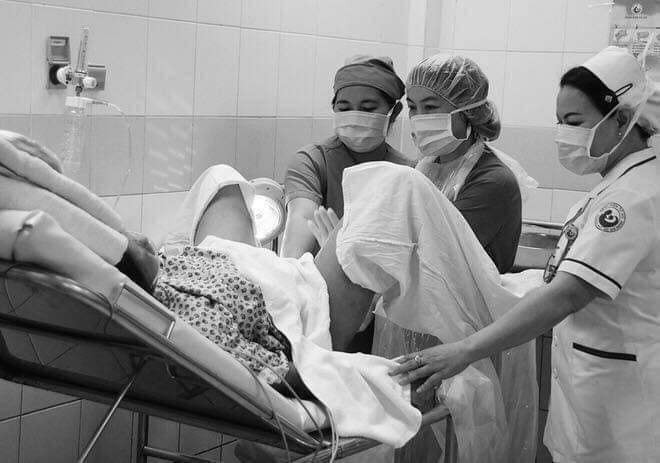 Sau khi nằm 2 tiếng trong phòng sau sinh,được bác sĩ đẩy ra ngoài,câu đầu tiên tôi được nghe từ chồng :" đến giờ còn chưa được ngủ tý nào đây!"

Nếu ai đã đọc thì nên đọc cho hết nhé . Xin cảm ơn!

Trước khi đọc, tôi cũng phải nhấn mạnh là, trường hợp phía dưới bài viết này, không phải là tất cả. Kể cả với chính tôi. Các ông chồng, câu chuyện này là dịch, trên mạng, không phải tôi viết hay bịa ra.

Trước tiên, về mặt sinh lí, người phụ nữ phải trải qua một cơn đau thập tử nhất sinh.

Tôi đã từng hỏi rất nhiều người phụ nữ trải qua sinh nở, họ đều nói, sinh thường đau đến cỡ nào, đau cỡ bác sĩ dùng dao rạch tầng sinh môn mà không dùng đến thuốc tê bởi vì những cơn đau khi sinh đã vượt qua nỗi đau đớn cắt da cắt thịt kia rồi.

Còn sinh mổ đau đến cỡ nào? Bạn bước ra từ phòng mổ, trên bụng có một vết sẹo dài đến mười mấy phân, khi hết thuốc tê chỉ cần hơi cử động đã đau buốt ruột gan. Đi vệ sinh hai chân đều không ngừng run rẩy, đi tiểu được một nửa phải dừng lại một lát, hít thở sâu mới có thể đi tiếp.

Nằm trên bàn mổ, đèn bật sáng, được tiêm một liều thuốc tê nửa thân dưới, sản phụ hoàn toàn có ý thức, mắt mở đăm đăm cảm nhận được bác sĩ dùng dao, rạch từng lớp từng lớp da bụng, rạch tử cung để đưa đứa bé ra ngoài. Giống như một linh kiện điện tử bị tháo ra, sau đó lại được ráp lại.

Lúc này, cái phụ nữ cần chính là sự nhẫn nại, dịu dàng vô điều kiện của chồng bên cạnh, hiểu được sự đau đớn và cô đơn của vợ khi vượt cạn.

Thế nhưng có những người chồng lại không làm được.

Đến hai bệnh viện sản nổi tiếng ở thủ đô, chúng tôi đứng ở ngoài cửa phòng sinh, quan sát xem khi người vợ đang đau đớn sinh con thì các ông chồng đang làm gì.

Thì ra những tình tiết như ngôn tình trên phim đều là bịa đặt. Trong phim, khi sản phụ ở trong phòng sinh, người chồng ở bên ngoài vô cùng nóng ruột, vò đầu bứt tai, đi qua đi lại, thi thoảng lại ngóng qua tấm cửa kính nhìn vào phòng sinh. Chỉ cần có một chút động tĩnh là lập tức xông lên hỏi y tá, vợ tôi thế nào rồi, cô ấy có làm sao không?

Hiện thực hoá ra phũ phàng hơn rất nhiều, hành động nôn nóng đó không phải của chồng mà là của bố mẹ sản phụ. Họ một giây cũng không ngồi yên, đứng trước cửa phòng sinh, căng thẳng chờ đợi.

Còn đại đa số các ông chồng, đều ngồi trên ghế, căng thẳng ….. chơi game. Có người ngồi trên ghế chơi điện thoại, có người còn trực tiếp đứng trước cửa thang máy, đơn giản vì ở đó có ổ cắm sạc điện thoại.

Tôi nhìn thấy một anh chàng béo đứng trước phòng chờ sinh gọi điện thoại cho vợ.

Anh ta nói:

” Alo,

Em nằm ở giường nào, giường số 12 hả?

Em mau hỏi bác sĩ xem anh và mẹ đợi em ở trước phòng sinh hay là về nhà đợi?

Dù sao cũng chẳng biết em khi nào mới sinh, cả nhà lại không được vào.

Anh đưa mẹ xuống lầu đi ăn cơm, có chuyện gì em nhờ y tá đi. Lát có gì gọi cho anh”.

Điện thoại còn chưa cúp, đã thấy anh ta và mẹ gấp rút lao đến trước cửa thang máy, kịp thời chen vào cánh cửa thang máy còn chưa kịp đóng lại. Tôi chưa từng gặp một người béo nào lại chạy nhanh như thế.

Tỉ mỉ quan sát, tôi phát hiện ra khi ngồi đợi sinh, trang bị của người nhà cũng không giống nhau.

Đàn ông đợi vợ, vật tuỳ thân gồm có: điện thoại, ví tiền, thuốc lá, nước, sạc dự phòng…

Còn mẹ đợi con gái sinh, vật đem theo lại là quần áo, khăn, đồ ăn, canh nóng, nước sôi…

Chúng tôi còn nhìn thấy một màn, khi người mẹ còn nằm trong phòng mổ, đứa trẻ được đưa ra ngoài trước.

Chồng và mẹ chồng lập tức vui mừng lao đến, đem theo điện thoại quay phim, chụp ảnh cả một đoạn hành lang,
âu yếm gọi con:” Con yêu, nhìn bố, cười một cái nào…”

Chụp ảnh cả nửa ngày mới nghĩ ra, hình như quên mất chuyện gì đó. Lúc này mới hỏi:” Thế vợ tôi đâu rồi?”

Khi phỏng vấn một bác sĩ nổi tiếng của bệnh viện sản, cô ấy nói có một chuyện làm cô ấy có ấn tượng rất sâu, vào mùa đông, đúng ca trực của cô ấy, có một người phụ nữ vừa sinh xong. Chồng và gia đình chồng lập tức chạy đi chụp ảnh đứa bé, còn hỏi mật mã wifi để đăng lên mạng xã hội.

Sản phụ một mình nằm trên chiếc giường trong phòng hồi sức. Lúc ấy trời rất lạnh, người phụ nữ đó không ngừng run rẩy. Bố của sản phụ lập tức cởi áo ngoài ra đắp cho cô ấy. Người ông ấy rất gầy, bên trong mặc độc một chiếc áo cộc tay.

Còn người chồng, vừa cao vừa to, mặc áo len áo khoác lại không hề nghĩ đến chuyện nên làm chút gì đó cho vợ mình.

Thực sự, một người đàn ông yêu hay không yêu bạn, chỉ có đến khoa sản mới biết. Khoa sản là nơi có thể nhìn ra được thứ tự quan trọng nhất trong lòng người đàn ông.

Rốt cuộc là vợ quan trọng hay con quan trọng?

Một bác sĩ nói, cô ấy làm việc đã 10 năm, đỡ đẻ cho khoảng trên 1000 đứa trẻ. Chỉ có một người đàn ông, trong quá trình chờ sinh rớt nước mắt nhờ cô ấy, bác sĩ, làm ơn giúp vợ tôi đỡ đau đớn đi một chút có được không?

Có rất nhiều người chồng, rất nhiều bà mẹ chồng, điều họ quan tâm nhất chỉ là trong quá trình sinh, làm thế nào mới tốt cho đứa trẻ.

Ví dụ như có những người nghe nói tiêm thuốc giảm đau không tốt cho đứa trẻ, thế là họ hỏi bác sĩ, không tiêm có được không?
Giữa vợ và con, có những người chồng sẽ chọn con?

Vậy rốt cuộc vợ và tiền cái nào quan trọng?

Có người sẽ chọn tiền.

Ví dụ như nghe bác sĩ nói, tiêm thuốc gây tê màng cứng là chi phí phát sinh, không nằm trong diện bảo hiểm, nghe xong giá tiền, có người sẽ ngập ngừng hỏi vợ, em có chịu đau được không?

Hoặc ví dụ, sinh mổ đắt hơn sinh thường, có người chồng sẽ nói, em cố một chút, chúng ta không mất tiền oan.

Đối với họ, cảm giác của vợ, sự đau đớn của vợ đều không đáng giá.

Vậy rốt cuộc vợ quan trọng hay mẹ họ quan trọng hơn?

Trường hợp khoa sản thường gặp nhất là có lúc, người vợ đau quá muốn sinh mổ, người chồng vốn đã mềm lòng chuẩn bị kí cam kết. Kết quả mẹ chồng nói, vẫn là sinh thường tốt cho đứa trẻ, hơn nữa trong vòng hai năm có thể sinh tiếp, cố đẻ thường đi.

Chồng lập tức liền buông giáp đầu hàng, nghe lời mẹ, điều này làm người vợ vô cùng tuyệt vọng.

Có lúc người vợ đau vô cùng, không chịu được rên la to tiếng, chồng vốn dĩ cũng rất thương xót vợ.

Kết quả mẹ chồng bên cạnh nói, đau đến thế hay sao, mẹ ngày xưa vừa sinh đã lập tức ra đồng, con gái bây giờ tiểu thư quá.
Chồng lập tức nói theo, cũng phải, đàn bà ai cũng phải đẻ, có phải mình em biết đẻ đâu. Những lời này tính sát thương còn hơn cả bị trúng một đao.

Suy cho cùng, đàn ông làm như vậy, khiến phụ nữ buồn là vì họ không hề xem vợ là người thân yêu nhất, thậm chí còn không xem vợ là người một nhà. Em xem anh là chồng, anh lại chỉ xem em là máy đẻ. Và máy đẻ thì không biết đau.

Khi mới kết hôn, đàn ông ai cũng thề non hẹn biển, bất kể ốm đau hay khoẻ mạnh, giàu có hay nghèo khó, đều sẽ vĩnh viễn yêu, tôn trọng, bảo vệ cô ấy suốt đời… Mấy lời này trong thời khắc vợ sinh con, rất nhiều người dường như đã quên sạch sẽ.
Chỉ có lúc sinh con, phụ nữ mới có thể nhìn ra được con người thật của chồng mình.

Hoá ra không phải hôn nhân, phòng sinh mới là nấm mồ của tình yêu. Và giá như người đàn ông nào cũng nếm thử nỗi đau đớn của vợ, có lẽ sẽ không còn những người mẹ trầm cảm
Tóm lại, đọc để biết đi các ông, nếu còn chưa thương vợ lắm!

-Kim Ngọc chia sẻ-