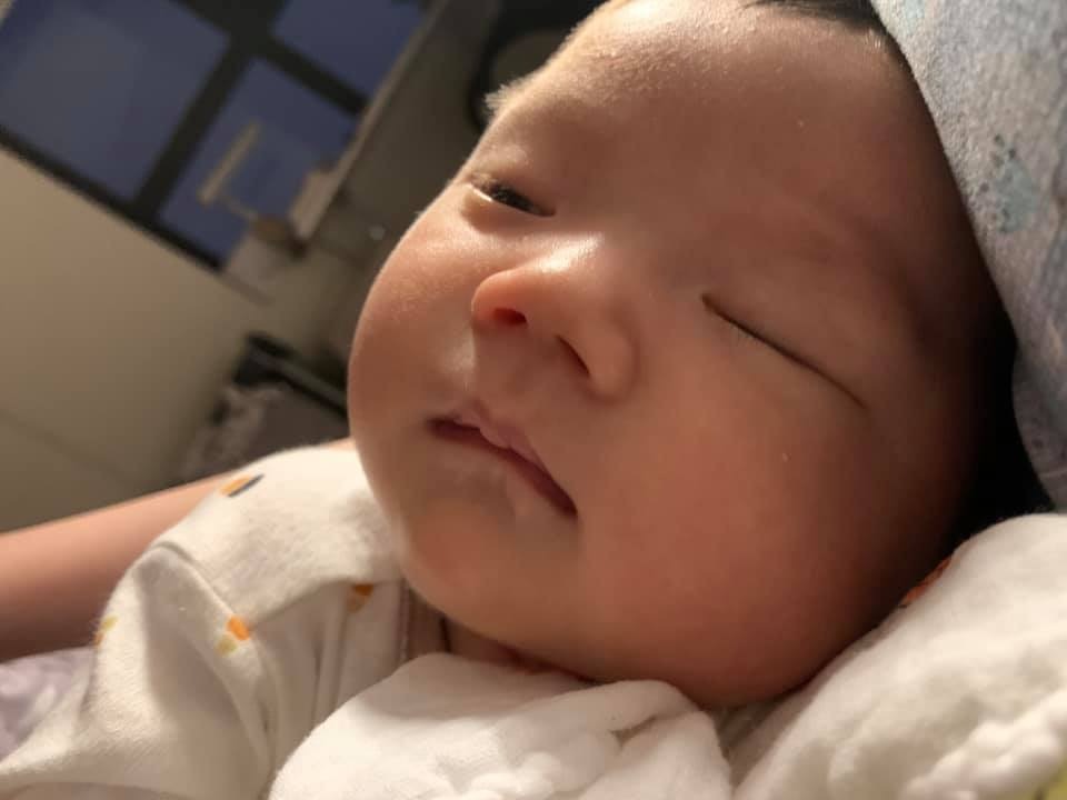 Review đi đẻ tại Hồng Ngọc Yên Ninh (dù lúc đăng kí gói thai sản được hẹn gặp lại ở Mỹ Đình hmmm)

Xin chào các mom, em mới sinh ở HN đc 5 tuần, trong giây phút bình yên hiếm hoi giữa WW5, em xin đc kể lại câu chuyện đi đẻ của em cho các mom cùng nghe :))

Đúng ngày này 5 tuần trước, đang ngủ trưa thì em phát hiện vỡ ối, liền lập tức quơ hết túi tắm bị bọc (dù viện có đủ đồ rồi nhưng em vẫn mang cả thế giới đi), gọi điện cho chồng mà giọng 2 đứa đều run cầm cập. Khi đó em đã 40w1d nên cả nhà đều ngóng bé lắm rồi, nên lúc thấy có dấu hiệu thì phấn khởi lắm haha (mấy tiếng sau mới biết thế nào là lễ độ :))

Đến viện, em đc cho lên xe lăn đẩy lên tầng 13 ngay, em cứ nói tự đi được nhưng bạn y tá không cho tự đi. Đến nơi em được siêu âm và khám trong ngay và luôn, mới rỉ ối, chưa mở tí nào! Con thì nặng 3636gr nên anh Tú bảo cứ theo dõi, kích thích các kiểu dần đi rồi nếu ko được thì mổ. Sau đó em được đưa đi thay quần áo và nằm máy monitor. 

Cho đến tận 6-7h tối em vẫn chỉ có cơn gò nhẹ tầm mức 40-50 nên vẫn nhởn nhơ lắm. Hôm đấy ở khoa sản có cặp đôi người nước ngoài đến khám mà bác sĩ cần phiên dịch, vừa hay em mới khai nghề nghiệp là giảng viên ngoại ngữ và chồng là bác sĩ, nên được triệu hồi đi phiên dịch luôn :))) nghĩ lại cái cảnh lần đầu đi dịch mà khệnh khạng đóng bỉm thật ko nhịn đc cười :)) Em có bảo thế này viện phải giảm viện phí cho em nhưng đương nhiên làm gì có chuyện đó :))

Lúc sau em bắt đầu có nhiều cơn đau mạnh hơn. Lúc này bs khám em đã mở 1 phân, xoá gần hết, ctc mềm mại, có khả năng sinh thường. Em lại tiếp tục nằm máy (đau quằn quại huhu) đến tầm 12h đêm thì mở được thành 4 phân, bs đưa vào phòng sinh cho làm giảm đau. Bs giảm đau rất ân cần nhẹ nhàng, và chỉ một lát sau, mặc dù cơn đau lên tận tần số 80-90, em chỉ thấy hơi đau xíu và ngủ đến gần sáng :))

Đến tầm 4h sáng, em tỉnh dậy với cơn đau dữ dội, lúc này tần số cơn đau đã hơn 100, em cảm thấy thuốc giảm đau ko có tác dụng mấy nữa nên cầu xin bác sĩ cho em thêm thuốc (như một con nghiện :)) Các mom yên tâm là chồng được vào cùng để các mom tha hồ cấu xé níu vịn mắng mỏ nhé :)) Sau khi tăng liều lên thì em hết hẳn đau, nhưng cũng hết hẳn buồn rặn luôn, mở 10 phân mà không cảm thấy gì. 

Sau đó bác sĩ Tú có hướng dẫn em rặn theo chỉ số cơn đau trên máy (bs nhìn máy và chỉ huy rặn), nhưng không ăn thua vì con em không chịu xuống, và hình như là bé ngửa mặt lên nên khó chui ra.
Vậy là em chuyển sang giai đoạn 2: mổ đẻ!

Lúc đó em tiếc công chịu đau cả đêm + sợ hãi các kiểu nên cứ âm thầm khóc. Khi được đẩy vào phòng mổ, em chỉ nhớ láng máng là rất đông người, mỗi ng một việc cực kì chuyên nghiệp, gắn rất nhiều máy móc, phủ vải xanh và tiêm vào người em. Có hẳn một bác sĩ nam đứng ở đầu giường mổ để hỏi han trấn an em, rằng mổ nhanh lắm, không đau đâu, sắp được gặp con rồi.... 

Quả thật chỉ tầm 10p sau là em bé ra đời! Em còn nhớ y nguyên giọng bác Tú lúc đó: "Đây rồi công chúa của bác đây rồi!" sau đó các cô bế bé đi vệ sinh và mặc quần áo. Anh Tú còn dặn dò động viên em gì nữa mà em ko thể nhớ nổi. Mới chỉ thấy cái chân con thôi mà em khóc quá trời, làm anh bác sĩ đứng đầu giường lại phải dỗ :)) quá mệt :))

Sau đó em được đưa đi nằm ở phòng theo dõi còn bé đi gặp bố và bà, rồi cũng đi theo dõi luôn. Phòng theo dõi của mẹ rất sạch đẹp hiện đại, nhân viên y tế ai cũng nhẹ nhàng ấm áp làm em cảm động lắm luôn (lại khóc hic), chắc tại bị truyền nhiều oxytoxin nên em cảm thấy hạnh phúc thái quá chăng? :))

5 ngày sau ở viện em được thăm khám rất thường xuyên, ai cũng nhẹ nhàng, được cho ăn 6 bữa/ ngày, ở phòng riêng 1210 sạch sẽ, view siêu to rộng. Cần gì chỉ cần ấn nút là sẽ có những cô y tá điều dưỡng xinh đẹp vào thăm hỏi ngay.

Tổng chi phí đẻ sau khi trừ BHYT là rơi vào tầm 3 mấy triệu em ko nhớ, rất đáng đồng tiền bát gạo. Mổ không đau là có thật, ngày thứ 2 em đã đi lại được, bế con các kiểu. Vết mổ đẹp, chồng em là bác sĩ còn phải khen chưa bao giờ thấy ai khâu khéo như anh Tú.

Đó, giờ thì em đang nằm trông cục bông ngủ và viết review này. Chúc các mom cũng có quyết định sáng suốt như em :)) và đừng sợ đẻ mổ, em còn tiếc là k mổ luôn từ đầu cho đỡ đau với cả bị khám trong ngại vch :))