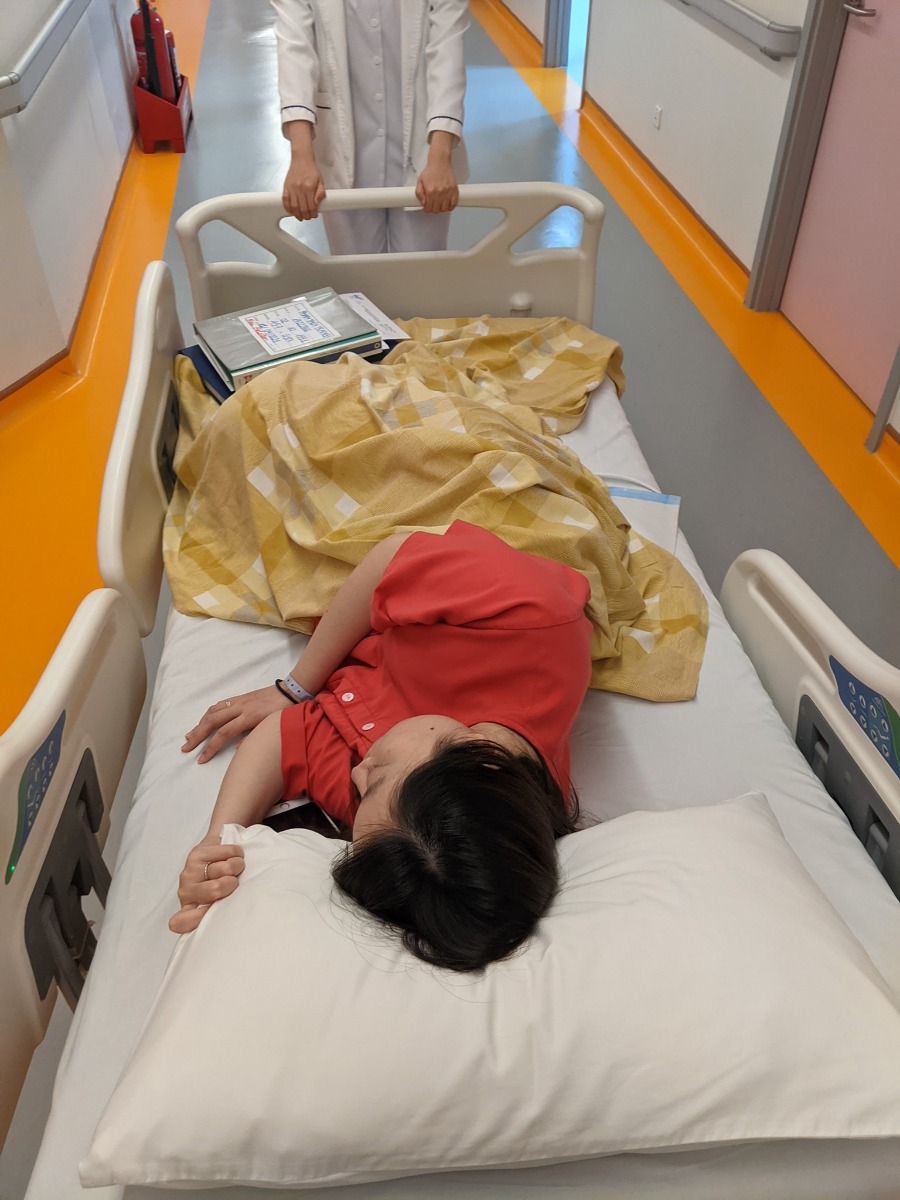 NHẬT KÝ VƯỢT CẠN TẠI BV VIỆT PHÁP HN - CẢM XÚC HÌNH SIN

Vợ mình bắt đầu có dấu hiệu chuyển dạ lúc 11h30p đêm ngày 10/04. Cơn chuyển dạ đến tư từ, không quá dồn dập nhưng mỗi lúc một tăng lên cả về cường độ lẫn chu kỳ. Vợ mình khá là kém khoản chịu đau nhưng lần này thật bất ngờ khi vẫn nhắm mắt nằm đến khi trời sáng khi tự mình vượt qua trên dưới 10 cơn đau chuyển dạ với cường độ mỗi lúc một tăng.

Sáng 11/04, lúc 5h00 phút. Vợ mình nhận chỉ định nhập viện do CTC đã mở được 1cm đầu tiên. Lúc này tâm trạng khá hồi hộp và vui mừng. Mình tất tưởi chạy đi làm thủ tục nhập viện và đặt phòng Single + Visitor cho 1 đêm sinh thường tại HFH. Trong lúc đó vợ mình được di chuyển lên phòng chờ và gắn máy Monitor theo dõi liên tục. 7h35p vợ mình vỡ ối, mình và vợ đều sẵn sàng cho cuộc vượt cạn. Trước khi làm giảm đau, gây tê ngoài màng cứng, thực sự là quãng thời gian khó khăn nhất khi những cơn đau đến ngày một dồn dập, vợ mình bị cơn đau chế ngự hoàn toàn.

11h00 vợ mình hoàn thành gây tê ngoài màng cứng, và di chuyển lên phòng đẻ số 3. Lúc này CTC đã mở được 4 cm. Tâm trạng cả 2 vợ chồng đều rất vui vì mọi thứ đều theo lộ trình ước tính trước đó. Cho đến khi Bác sỹ khám khi CTC đã mở đc 9 cm, Bác sỹ mặt co lại, xám xịt và thông báo với mình 1 tin, khiến mình và vợ mình mất hoàn toàn bình tĩnh. Nguyên văn "Em bé ngửa mặt lên đồng thời, monitor đã hoàn toàn không bắt được tim thai trong 10p" mình đứng ngay sát vợ lắng nghe từng câu chữ, mắt thì nhìn máy monitor chỉ 1 dấu ? vàng ệch trên màn hình monitor. Sau 1p suy nghĩ, bác sỹ và mình đều đưa ra quyết định. Mổ đẻ khẩn cấp. Sau khi nghe tin, người vợ mình run lên liên hồi, phần do lạnh, phần do lo sợ. Lo sợ cho sự an nguy của con gái mình.

Sau khi ký tá mọi giấy tờ và ký vào bản cam kết phẫu thuât với lý do Thai ngửa, Suy thai. Yêu cầu mổ gấp. Mình quay lại với vợ, chỉ kịp hôn lên trán vợ và nói "2 mẹ con cố lên, bố biết 2 mẹ con sẽ làm được" rồi đứng như trời trồng khi nhìn xe đẩy, đẩy chiếc giường vào phòng mổ trong khi các bác sỹ vẫn liên tục truyền các lọ thuốc vào tay vợ mình.
Lúc đấy, cổ họng mình nghẹn lại. Nhưng vẫn nhanh chóng chạy thẳng xuống Khoa Sản, nhận quần áo sạch, tắm và sát trùng cơ thể để tiến hành Da kề da với con gái. 1 phút rồi 5 phút rồi 10 phút, thời gian mình đếm đến từng tíc tắc. Chỉ một mình mình với cái hành lang màu hồng. Lần đầu tiên mình chảy nc mắt vì sợ hãi và cô độc.

13h35p. Chị chăm sóc kéo theo 1 xe lồng. Mình chạy đến hỏi chị. Chị ơi, em bé của bạn Phạm Thùy Trang đúng không chị? Chị nói "Đúng rồi! Em ra ngoài lúc 13h28p, em gái và em nặng 2.5kg. Sức khoẻ của em và mẹ đều tốt. Anh nằm xuống để mình Da kề da với em nhé". Mình đỡ con vào lòng, hỏi liên tục chị chăm sóc về thông tin của vợ. Chị trấn an mình bằng thông tin rằng vợ mình vẫn tỉnh táo, các bác sỹ đang tiến hành phần còn lại của ca phẫu thuật. Vừa da kề da với con mà nước mắt ngấn lên. Phần vì hạnh phúc, phần vì lo cho vợ.

16h55p. Vợ mình đc trả về phòng. Mình cùng con đi về với vợ. Cho đến khi mình gặp được vợ, thấy vợ tỉnh táo tươi cười. Lúc đó cơ hàm, cơ mặt, cơ tay mới thực sự đc thả lỏng. Mình trả con cho vợ và tự nhủ. Thành công rồi, mình làm bố rồi!!!

Một trải nghiệm đưa vợ đi đẻ mà có lẽ mình sẽ không thể nào quên được. Từng cung bậc cảm xúc mình từ vui mừng đến kinh hãi, lo lắng cho đến hạnh phúc khi nhìn vợ con bình an trở về.

P/s: Cháu chào các cô các chú. Cháu tên là Tuệ Minh, tên ở nhà là Tô. Cháu nặng 2.5 kg và thích được xoa lưng đi ngủ ạ. Các cô, các chú ủn mông cho cháu hay ăn chóng lớn nha. 🥳🥰👶

P/s 2: Chân thành cảm ơn Bác sỹ Nghị cùng kíp trực đã đỡ đẻ cho vợ em. Với sự chân thành, cẩn thận và tâm huyết hết mực. Cảc ơn Bác sỹ Quyết và Bác sỹ Thu đã tận tình thăm khám trong suốt thai kỳ. Em chắc chắn sẽ chọn HFH tại tập 2. Các mẹ yên tâm khi lựa chọn HFH nhaa.