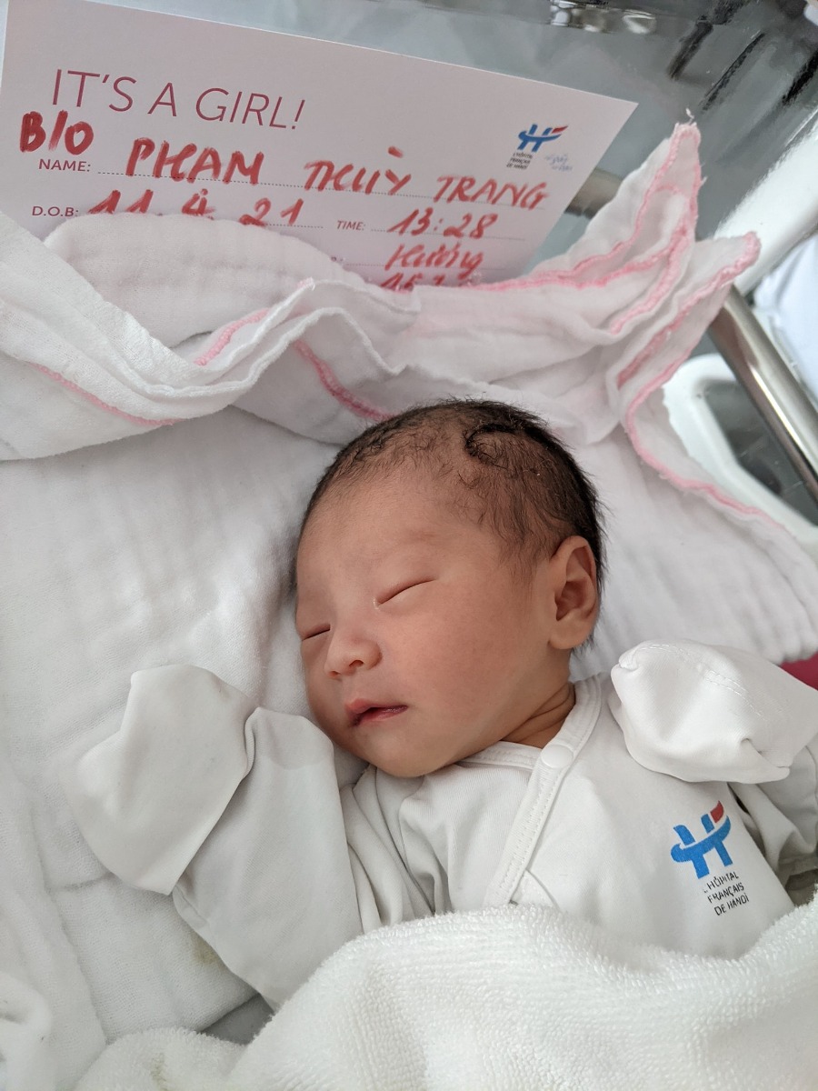 NHẬT KÝ VƯỢT CẠN TẠI BV VIỆT PHÁP HN - CẢM XÚC HÌNH SIN

Vợ mình bắt đầu có dấu hiệu chuyển dạ lúc 11h30p đêm ngày 10/04. Cơn chuyển dạ đến tư từ, không quá dồn dập nhưng mỗi lúc một tăng lên cả về cường độ lẫn chu kỳ. Vợ mình khá là kém khoản chịu đau nhưng lần này thật bất ngờ khi vẫn nhắm mắt nằm đến khi trời sáng khi tự mình vượt qua trên dưới 10 cơn đau chuyển dạ với cường độ mỗi lúc một tăng.

Sáng 11/04, lúc 5h00 phút. Vợ mình nhận chỉ định nhập viện do CTC đã mở được 1cm đầu tiên. Lúc này tâm trạng khá hồi hộp và vui mừng. Mình tất tưởi chạy đi làm thủ tục nhập viện và đặt phòng Single + Visitor cho 1 đêm sinh thường tại HFH. Trong lúc đó vợ mình được di chuyển lên phòng chờ và gắn máy Monitor theo dõi liên tục. 7h35p vợ mình vỡ ối, mình và vợ đều sẵn sàng cho cuộc vượt cạn. Trước khi làm giảm đau, gây tê ngoài màng cứng, thực sự là quãng thời gian khó khăn nhất khi những cơn đau đến ngày một dồn dập, vợ mình bị cơn đau chế ngự hoàn toàn.

11h00 vợ mình hoàn thành gây tê ngoài màng cứng, và di chuyển lên phòng đẻ số 3. Lúc này CTC đã mở được 4 cm. Tâm trạng cả 2 vợ chồng đều rất vui vì mọi thứ đều theo lộ trình ước tính trước đó. Cho đến khi Bác sỹ khám khi CTC đã mở đc 9 cm, Bác sỹ mặt co lại, xám xịt và thông báo với mình 1 tin, khiến mình và vợ mình mất hoàn toàn bình tĩnh. Nguyên văn "Em bé ngửa mặt lên đồng thời, monitor đã hoàn toàn không bắt được tim thai trong 10p" mình đứng ngay sát vợ lắng nghe từng câu chữ, mắt thì nhìn máy monitor chỉ 1 dấu ? vàng ệch trên màn hình monitor. Sau 1p suy nghĩ, bác sỹ và mình đều đưa ra quyết định. Mổ đẻ khẩn cấp. Sau khi nghe tin, người vợ mình run lên liên hồi, phần do lạnh, phần do lo sợ. Lo sợ cho sự an nguy của con gái mình.

Sau khi ký tá mọi giấy tờ và ký vào bản cam kết phẫu thuât với lý do Thai ngửa, Suy thai. Yêu cầu mổ gấp. Mình quay lại với vợ, chỉ kịp hôn lên trán vợ và nói "2 mẹ con cố lên, bố biết 2 mẹ con sẽ làm được" rồi đứng như trời trồng khi nhìn xe đẩy, đẩy chiếc giường vào phòng mổ trong khi các bác sỹ vẫn liên tục truyền các lọ thuốc vào tay vợ mình.
Lúc đấy, cổ họng mình nghẹn lại. Nhưng vẫn nhanh chóng chạy thẳng xuống Khoa Sản, nhận quần áo sạch, tắm và sát trùng cơ thể để tiến hành Da kề da với con gái. 1 phút rồi 5 phút rồi 10 phút, thời gian mình đếm đến từng tíc tắc. Chỉ một mình mình với cái hành lang màu hồng. Lần đầu tiên mình chảy nc mắt vì sợ hãi và cô độc.

13h35p. Chị chăm sóc kéo theo 1 xe lồng. Mình chạy đến hỏi chị. Chị ơi, em bé của bạn Phạm Thùy Trang đúng không chị? Chị nói "Đúng rồi! Em ra ngoài lúc 13h28p, em gái và em nặng 2.5kg. Sức khoẻ của em và mẹ đều tốt. Anh nằm xuống để mình Da kề da với em nhé". Mình đỡ con vào lòng, hỏi liên tục chị chăm sóc về thông tin của vợ. Chị trấn an mình bằng thông tin rằng vợ mình vẫn tỉnh táo, các bác sỹ đang tiến hành phần còn lại của ca phẫu thuật. Vừa da kề da với con mà nước mắt ngấn lên. Phần vì hạnh phúc, phần vì lo cho vợ.

16h55p. Vợ mình đc trả về phòng. Mình cùng con đi về với vợ. Cho đến khi mình gặp được vợ, thấy vợ tỉnh táo tươi cười. Lúc đó cơ hàm, cơ mặt, cơ tay mới thực sự đc thả lỏng. Mình trả con cho vợ và tự nhủ. Thành công rồi, mình làm bố rồi!!!

Một trải nghiệm đưa vợ đi đẻ mà có lẽ mình sẽ không thể nào quên được. Từng cung bậc cảm xúc mình từ vui mừng đến kinh hãi, lo lắng cho đến hạnh phúc khi nhìn vợ con bình an trở về.

P/s: Cháu chào các cô các chú. Cháu tên là Tuệ Minh, tên ở nhà là Tô. Cháu nặng 2.5 kg và thích được xoa lưng đi ngủ ạ. Các cô, các chú ủn mông cho cháu hay ăn chóng lớn nha. 🥳🥰👶

P/s 2: Chân thành cảm ơn Bác sỹ Nghị cùng kíp trực đã đỡ đẻ cho vợ em. Với sự chân thành, cẩn thận và tâm huyết hết mực. Cảc ơn Bác sỹ Quyết và Bác sỹ Thu đã tận tình thăm khám trong suốt thai kỳ. Em chắc chắn sẽ chọn HFH tại tập 2. Các mẹ yên tâm khi lựa chọn HFH nhaa.