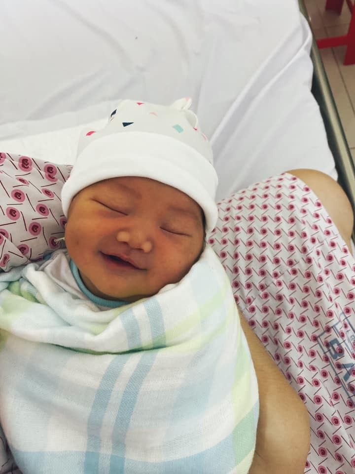 Review hành trình đi sinh của mình tại Từ Dũ!

Chào các bạn. Mình vừa sinh bé tại Từ Dũ ngày 31/5 vừa rồi. Hành trình đi sinh của mình trong xui có mà may cũng có, người ta nói trong cái rủi có cái may. Kaka

Trong quá trình mang thai em bé, mình đi khám tại mekong từ W1-W28. Vì mình có bảo hiểm Generali do công ty mua cho nhân viên. Mình ko theo bác sĩ nào cả, qua tuần 28 mình quyết định tìm 1 phòng khám gần nhà ( nhà mình ở Gò Vấp) và 1 bác sĩ để theo luôn thì tình cờ mình xem được vài Review về phòng khám bầu 101, của bác sĩ Nguyễn Tấn Thành, và mình theo anh Thành tới khi mẹ tròn con vuông và đây là quyết định đúng đắn nhất của mình luôn á!

Trong suốt quá trình thai kì tới lúc tại bệnh viện, mình ko chê được điểm nào nên bạn nào muốn tìm được một bác sĩ có tâm, nhiệt tình, mát tay thì phòng khám Bầu 101 và bác sĩ Thành là một sự lựa chọn vô cùng đúng đắn!

Trở lại quá trình mình đi đẻ, thai mình bước qua tuần 40 nhưng vẫn ko có dấu hiệu chuyển dạ, nên bsi nói sáng hôm sau nhập viện tuy nhiên chiều tối hôm đó sau khi thăm khám, bác sĩ nói cổ tử cung mới mở đc 2 phân( mình ko thấy đau bụng hay ra huyêt gì), chiều tối về mình thấy ra máu khá nhiều nên cả nhà quyết định nhập viện. Nhưng trớ trêu thế này, chồng mình vô tình liên quan tới 1 ca covid dương tính mặc dù ko tiếp xúc gì nhưng công ty yêu cầu lấy mẫu ( đã âm tính) và tự cách ly tại nhà nên chồng mình ko thể đưa mình đi sinh. Nhà ngoại thì ở Hà Nội do dịch cũng ko thể vào SG, bố mẹ chồng đều đã già cả ốm yếu nên chỉ còn chị dâu đưa mình vô viện. Khi vô cấp cứu khai báo y tế thì bệnh viện yêu càu 2 chị em cách ly ở khu riêng và lấy mẫu xét nghiệm Covid ở Khu G . Khu này h ko có người, rất cũ, còn nhiều muỗi, nói thật mình nhìn giống khu nhà ma vì ko có ai ở đó luôn. Các anh chị test mẫu nói nếu mẫu của mình âm tính mới cho mình về lại khu sản A như 1 sản phụ bình thường. Thời gian có mẫu từ 24-48h.Nếu chuyển dạ trước khi có mẫu thì sẽ phải sinh tại khu đó luôn và đồng nghĩa với việc mình ko thể được bác sĩ của mình đỡ sinh. Lúc ở trong đó buồn ko tả, tủi thân vô cùng. Ko có chồng, ko có mẹ, phòng nóng bức lại nhiều muỗi ko ngủ được, lại sợ phải vượt cạn trong tình trạng ko có bác sĩ Thành và cơ sở vật chất như vậy. Huhu. Ở trong đó cũng ko đc ra ngoài mua đồ ăn, muốn mua thì phải nhờ ng xuống lấy.Nhưng chả thể làm gì ngoài động viên bản thân. Mình cứ nói con chờ mẹ có kết quả đợi chuyển qua khu dịch vụ con hãy ra con nhé...

May thay sáng sớm hôm sau 7g sáng mình đã có kết quả luôn và được đẩy qua khu sản A. Tại đây, ai nhìn bệnh án cũng hỏi e ở gò vấp hả, test mẫu chưa, có bị cách ly ko, ai cũng hỏi. Mình được đưa vào khu theo dõi chờ sinh. Tại đây người nhà phải ngồi ngoài ghế đá chờ đến giờ mới được thăm khám. Mà ngoài trời nóng bức quá. Mình thương chị dâu mình nên qua phòng trực hỏi có thể chuyển qua khu dịch vụ khu b ko? Vì khu này người nhà có thể cùng sản phụ lấy phòng trước trong lúc chờ chuyển dạ. Phòng trực check và may thay còn 1 giường 900k phòng 12 người mình ok liền, mình đóng tạm ứng 10tr và có hộ lý đưa mình qua khu đó. Khu B này đẹp và sạch sẽ lắm. 2 chị e mình chờ sinh tại phòng này và đăng kí khi nào có phòng 3 giường hoặc 2 giường thì xin chuyển qua. Lúc này mình liên tục nhắn tin cho bác sĩ Thành về tình trạng của mình. Anh nhiệt tình trả lời còn ghé kiểm tra xem tình hình của mình như thế nào nữa.

Tại đây mình được thăm khám, cổ tử cung mở 3 phân nên ko cần đặt bóng nước mà chỉ truyền thuốc kích sinh, 15h mình được truyền thuốc, cơn đau âm ỉ và được đưa xuống phòng chờ sinh. Vì ko nghĩ chiều đi sinh nên trưa mới ăn đc 1 bữa kaka. Tại phòng kích sinh lúc này ko đc gặp người nhà nữa. Tại phòng chờ sinh, mình sẽ được đăng kí các gói dịch vụ, và mình đk sinh dịch vụ, điền tên bác sĩ của mình. Tại đây có bán túi hồng của bệnh viện, các bạn nên mua túi này nha, tiện lợi vô cùng. Ở phòng chờ sinh thì nhiều sản phụ đang nằm chờ, mỗi ng 1 sắc thái đau khác nhau. Nhiều ng đau quá la, bỏ khẩu trang vì khó thở thì bị họ lý nhắc nhở liền nhưng mấy chị hộ lý cũng nhẹ nhàng, ko la mắng lại gì đâu ạ. Trong lúc thay đồ chờ sinh và đki dịch vụ thì mình bị vỡ ối, đang đi mà nước chảy ròng ròng, mình lên giường nằm gắn máy đo cơn gò và đo tim thai, thỉnh thoảng sẽ có mấy chị đưa tay vào kiểm tra xem mình nở đc bao nhiêu phân, nhưng các chị ktra rồi đều nói sao dày và cao quá đến 9g kém tối thì vẫn nở 3phân. Lúc này mình đau dữ dội từng cơn k chịu đc nên yêu cầu tiêm giảm đau, tiêm xong thấy đỡ hẳn. Lúc này mới sức nhớ mình chưa ăn uống gì suốt từ trưa.

1 Lúc sau, bác sĩ Thành của mình vào thăm khám ktra nói mình rặn thử, rặn như muốn đi cầu vậy á, ktra xong bsi nói 2 tiếng nưa nếu k chuyển biến sẽ chỉ định mổ. Bác vừa đi thì 15,20p sau cổ tử cung mình nở đc 5p, chắc e bé sợ mẹ phải mổ kaka. Rồi nhanh chóng mở 8p. Lúc này đau dữ lắm như muốn đi cầu, muốn rặn ngay lập tức thì mình báo hộ lý c ơi em muốn rặn lắm rồi, chị ấy nói vậy chị đưa e vào phòng sinh. Vào thì mình chưa thấy bsi của mình đâu mà mắc rặn quá. Hộ lý tại đó sẽ vệ sinh sát trùng và đặt mình nằm chờ sinh

Có 1 anh bsi khác vô ktra nói từ từ, cố chịu thêm xíu cho cổ tử cung mở, h rặn sợ rách tử cung. Mình cố nhịn tới khi bsi mình vào xong mình bắt đầu rặn. Vừa rặn mình vừa nghe tim thai, nhưng lúc đó đuối quá nên mình nhắm mắt nhắm mũi rặn, ki cần biết trời trăng gì nữa, bác sĩ của mình và hộ lý luôn miệng động viên mình cố gắng, xong bsi mình nói một hơi nữa thôi mình hít thở lấy 1 hơi thật sâu thì thấy nhẹ người, bsi lôi bé ra rồi cho mình da kề da. Khoảnh khắc đó mình quên hết đau luôn, thiêng liêng lắm. Mình nằm một lúc bsi khâu tầng sinh môn, lúc này mình ko hề thấy đau luôn, bsi nói a đã gọi báo cho chị mình rồi. Giờ mình nằm hồi sức 1,2 tiếng rồi sẽ đc đẩy về phòng. Bé da kề da với mình tầm khoảng 1 tiếng thì hộ lý tới cân đo và tiêm mũi K chống viêm màng não, cho mình uống thuốc. Bé trộm vía được bsi mát tay đỡ, được 3,4kg, mắt 2 mí , má lúm đồng tiền.😀

Về phòng thì chị mình xin đc chuyển thành công qua phòng 3 giường rồi. Có ghế bố cho ng thân nằm. Mỗi ngày sẽ đc thay nc nóng 2 lần, đồ cho mẹ và ga giường đc phát mỗi ngày, sau 24g bé sẽ đc tắm, thăm khám, đo nhiệt độ. Nói chung dịch vụ khu B khá tốt. Vì sinh thường nên hsau mình đi lại đc luôn, phần khâu thì hơi đau và tê nên ko sao hết. Mình tập đi lại để cơ thể hồi phục nhanh. Mỗi ngày bác sĩ sẽ thăm khám mẹ và bé xem có bất thường ko.

Ngày hsau bác sĩ của mình có ghé thăm mình 1 lần, chị mình còn khen bác sĩ nhiệt tình quá, nhắn tin gì cũng trả lời nhanh gọn. Ở từ dũ thì mình thấy cũng có ng cáu gắt, có ng dễ thương chắc cũng vì công việc họ nhiều quá nên nhiều khi họ cũng k thể tươi cười nhiều được. 
Tổng chi phí mình sinh hết hơn 15tr nhưng bảo hiểm đã chi trả cũng hơn 12tr r nên mình chỉ trả thêm 3tr1 cho chi phi khám bé, xỏ lỗ tai, xông hơi và thuốc bổ thôi. Mình nằm viện 3 ngày thì đc về. Nói chung đi sinh ở Từ Dũ cũng khá ổn, dvu chắc chắn sẽ k bằng các viện tư nhưng chuyên môn thì mình thấy họ bài bản lắm. Nói chung công cuộc vượt cạn lần này mình thấy Từ Dũ khá ổn và 100% ok về bác sĩ của mình.

Nếu còn lần sau chắc chắn mình sẽ theo bác sĩ Thành ngay từ đầu. 
Các bạn tham khảo nhé.