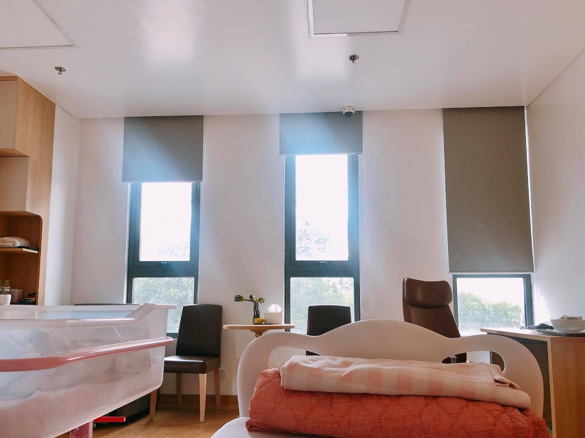 REVIEW ĐẺ MỔ BV HỒNG NGỌC - PHÚC TRƯỜNG MINH 😎

Mình đẻ từ 4/7. Nay mới ngoi lên kể lể chút về trải nghiệm đi đẻ ở đây 😂

Mình là thai đôi, đăng ký gói 36w đẻ mổ lần 1 - giá trong gói là 48,5tr - được giảm 10% vì đky nhóm 3 mẹ còn 43,650tr. Tập 1 là đẻ thường nên chưa có kinh nghiệm đẻ mổ phát nào nên đến ngày mổ cũng có chút lo lắng.

Mình đky khám và mổ bsy Tú. Trước ngày mổ 1 ngày bệnh viện sẽ gọi điện hẹn 11h trưa hôm sau. Dặn dò về vấn đề nhịn ăn uống, vào sớm trước 2 tiếng và giấy tờ, đồ đạc cần mang theo.

Đến hẹn m vào viện. Khám, siêu âm và chạy máy lần cuối. Trong lúc này người nhà đi nộp giấy tờ và làm thủ tục nhận phòng. Đợt này đang khuyến mãi nên các mẹ auto đều có phòng riêng. Vì nhà m sinh đôi nên up lên phòng Deluxe cho rộng, phát sinh thêm 1,250tr x 3 đêm.

Chạy máy xong thì các cô hộ lý sẽ thụt cho mẹ rồi phát quần áo, bỉm, giày dép để mẹ thay ạ. Hôm m đi mổ chắc ngày đẹp nên khá đông. Vào phòng hậu phẫu truyền nước chờ đến lượt đẻ mà ngủ đc 1 giấc. Khoảng 11h40 thì các bạn đập dậy “Chị ơi đi đẻ thôi”

Vào phòng phẫu thật thấy bác Tú đang chờ sẵn, trông bác hơi mệt, bác bảo sáng nay mổ 4-5 ca gì đó, chiều lại chiến tiếp… Các bạn trong ekip bắt đầu tiến hành các bước: tiêm gây tê màng cứng, gắn các loại dây dợ. Lúc tiêm hơi nhói tý, tầm 5p sau mất dần cảm giác là bác Tú bắt đầu mổ. Trong quá trình mổ có 1 bạn đứng buôn chuyện với mình. Mổ thì ko có cảm giác gì, nhanh lắm ạ. Khoảng 12 đã thấy bụng rút dần và 1 bạn oe oe, 3 phút sau bạn còn lại cũng lộ diện. Các cô lau qua cho 2 bạn rồi cho da kề da với mẹ và hỗ trợ 2 bạn tu ti mẹ luôn. 

Cậu anh rất hợp tác nhưng cậu em còn chưa quen, nên sau đó dù khâu xong xuôi các cô vẫn cố hỗ trợ cậu em và để em tu ti mẹ đc ít nhất 15p 😂. Khâu xong bác Tú chúc mừng 3 mẹ con và các bạn trong ekip làm nốt các việc còn lại. Sau đó bé đc bế ra cho người nhà nhìn và đưa về p chăm sóc sau sinh, mẹ thì về phòng hậu phẫu nằm theo dõi 3 tiếng.

Mổ xong lạnh run thực sự ạ. Nhưng tầm 1 tiếng sau thì lại nóng vã mồ hôi nên m ngủ chập chờn. Có các bạn nhân viên thấy m tỉnh rồi ra ngồi buôn chuyện cùng. Mãi cũng hết 3 tiếng đc về phòng gặp con và gặp người nhà.

Mổ buổi trưa đến đêm thì thuốc giảm đau hết tác dụng, m bắt đầu thấy nhức dần. Nghĩ chịu được nên ko ấn nút gọi y tá. Mãi gần sau đau vã mồ hôi mới ấn chuông thì các bạn vào nhét thuốc cho… Nên các mẹ mổ đau thì cứ mạnh dạn ấn gọi cô hỗ trợ nhé. Bsy Tú cũng dặn là “em ko cần tiết kiệm thuốc cho bệnh viện thế đâu” 😂. Sáng hôm sau thì m thấy cũng đỡ rồi nên chỉ gọi nhét thuốc đúng 1 lần đó thôi.

Một ngày sẽ có cực kỳ nhiều lượt bsy, y tá, hộ lý, mang đồ ăn, dọn phòng vào để thăm khám, làm nhiệm vụ của họ các mẹ nhé. Bé sẽ được các cô tắm vào buổi sáng. Mẹ đc chiếu tia plasma 4 lần. Vết mổ gọn lắm ạ 🥰. 

 Về dịch vụ thì ko có gì để chê cả. Ngày 3 bữa chính 2 bữa phụ đa dạng, tuỳ các mom chọn. Người nhà thì lên tầng 4 ăn. Em update hình ảnh 1 vài bữa cơm ở viện ạ.