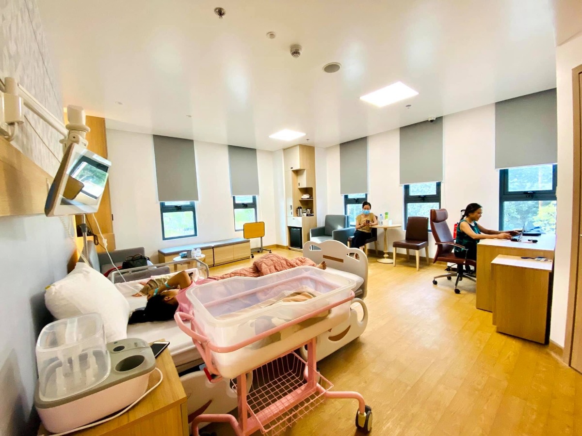 REVIEW ĐẺ MỔ BV HỒNG NGỌC - PHÚC TRƯỜNG MINH 😎

Mình đẻ từ 4/7. Nay mới ngoi lên kể lể chút về trải nghiệm đi đẻ ở đây 😂

Mình là thai đôi, đăng ký gói 36w đẻ mổ lần 1 - giá trong gói là 48,5tr - được giảm 10% vì đky nhóm 3 mẹ còn 43,650tr. Tập 1 là đẻ thường nên chưa có kinh nghiệm đẻ mổ phát nào nên đến ngày mổ cũng có chút lo lắng.

Mình đky khám và mổ bsy Tú. Trước ngày mổ 1 ngày bệnh viện sẽ gọi điện hẹn 11h trưa hôm sau. Dặn dò về vấn đề nhịn ăn uống, vào sớm trước 2 tiếng và giấy tờ, đồ đạc cần mang theo.

Đến hẹn m vào viện. Khám, siêu âm và chạy máy lần cuối. Trong lúc này người nhà đi nộp giấy tờ và làm thủ tục nhận phòng. Đợt này đang khuyến mãi nên các mẹ auto đều có phòng riêng. Vì nhà m sinh đôi nên up lên phòng Deluxe cho rộng, phát sinh thêm 1,250tr x 3 đêm.

Chạy máy xong thì các cô hộ lý sẽ thụt cho mẹ rồi phát quần áo, bỉm, giày dép để mẹ thay ạ. Hôm m đi mổ chắc ngày đẹp nên khá đông. Vào phòng hậu phẫu truyền nước chờ đến lượt đẻ mà ngủ đc 1 giấc. Khoảng 11h40 thì các bạn đập dậy “Chị ơi đi đẻ thôi”

Vào phòng phẫu thật thấy bác Tú đang chờ sẵn, trông bác hơi mệt, bác bảo sáng nay mổ 4-5 ca gì đó, chiều lại chiến tiếp… Các bạn trong ekip bắt đầu tiến hành các bước: tiêm gây tê màng cứng, gắn các loại dây dợ. Lúc tiêm hơi nhói tý, tầm 5p sau mất dần cảm giác là bác Tú bắt đầu mổ. Trong quá trình mổ có 1 bạn đứng buôn chuyện với mình. Mổ thì ko có cảm giác gì, nhanh lắm ạ. Khoảng 12 đã thấy bụng rút dần và 1 bạn oe oe, 3 phút sau bạn còn lại cũng lộ diện. Các cô lau qua cho 2 bạn rồi cho da kề da với mẹ và hỗ trợ 2 bạn tu ti mẹ luôn. 

Cậu anh rất hợp tác nhưng cậu em còn chưa quen, nên sau đó dù khâu xong xuôi các cô vẫn cố hỗ trợ cậu em và để em tu ti mẹ đc ít nhất 15p 😂. Khâu xong bác Tú chúc mừng 3 mẹ con và các bạn trong ekip làm nốt các việc còn lại. Sau đó bé đc bế ra cho người nhà nhìn và đưa về p chăm sóc sau sinh, mẹ thì về phòng hậu phẫu nằm theo dõi 3 tiếng.

Mổ xong lạnh run thực sự ạ. Nhưng tầm 1 tiếng sau thì lại nóng vã mồ hôi nên m ngủ chập chờn. Có các bạn nhân viên thấy m tỉnh rồi ra ngồi buôn chuyện cùng. Mãi cũng hết 3 tiếng đc về phòng gặp con và gặp người nhà.

Mổ buổi trưa đến đêm thì thuốc giảm đau hết tác dụng, m bắt đầu thấy nhức dần. Nghĩ chịu được nên ko ấn nút gọi y tá. Mãi gần sau đau vã mồ hôi mới ấn chuông thì các bạn vào nhét thuốc cho… Nên các mẹ mổ đau thì cứ mạnh dạn ấn gọi cô hỗ trợ nhé. Bsy Tú cũng dặn là “em ko cần tiết kiệm thuốc cho bệnh viện thế đâu” 😂. Sáng hôm sau thì m thấy cũng đỡ rồi nên chỉ gọi nhét thuốc đúng 1 lần đó thôi.

Một ngày sẽ có cực kỳ nhiều lượt bsy, y tá, hộ lý, mang đồ ăn, dọn phòng vào để thăm khám, làm nhiệm vụ của họ các mẹ nhé. Bé sẽ được các cô tắm vào buổi sáng. Mẹ đc chiếu tia plasma 4 lần. Vết mổ gọn lắm ạ 🥰. 

 Về dịch vụ thì ko có gì để chê cả. Ngày 3 bữa chính 2 bữa phụ đa dạng, tuỳ các mom chọn. Người nhà thì lên tầng 4 ăn. Em update hình ảnh 1 vài bữa cơm ở viện ạ.