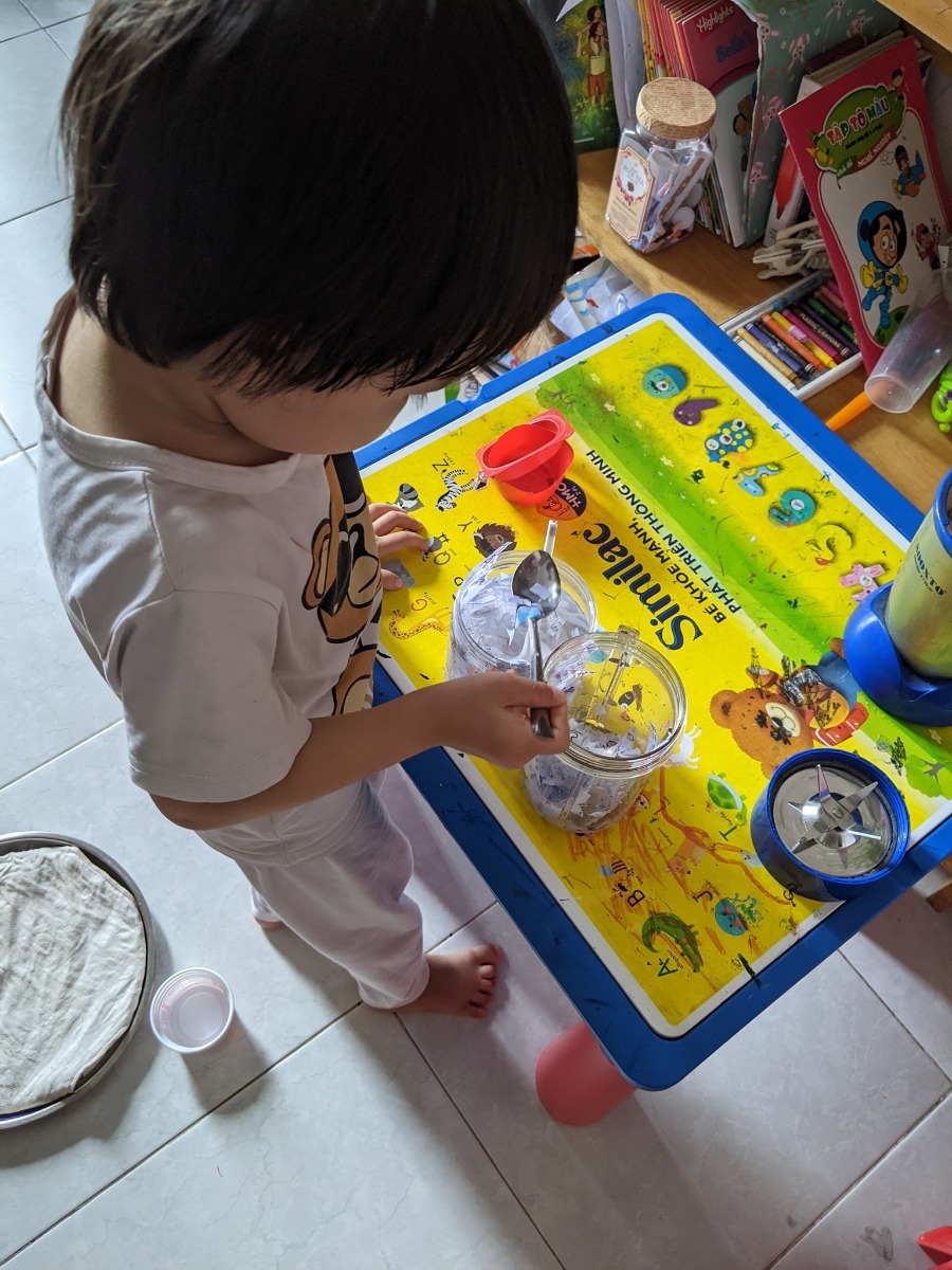 Hôm nay nắng to quá, nếu mình không đăng thì lại thấy phí cái nắng này. (Chứ mình cũng làm biếng lắm) chơi dơ miếng ha mọi người!

Làm giấy tái chế

1. Xé giấy dùng rồi, ngâm nước. Mình ngâm tầm 30p, bóp nát rồi bỏ máy xay sinh tố, xay lên.

2. Đổ hỗn hợp vào khuôn, ép xuống. Trong video youtube họ dùng khuôn hình vuông, có lót một màn mỏng. Nhưng mình không có, nên nảy ra một idea cắt vỏ sữa chua làm khuôn hình vuông, để một khăn xô bên dưới. Múc hỗn hợp giấy đổ vào, tán và ép xuống.

3. Đem phơi nắng.

4. Thành phẩm tô màu, làm note, vẽ tranh tùy thích.

Lúc cho bé xé giấy, mình đi làm việc khác, bé cứ siêng năng bị dụ thui ah.

Bây giờ làm, mai là mọi người có thành phẩm chơi rùi đó. Chiều qua mưa nhẹ. Em bé đem vào nhà để ở laptop mình cho nóng nhanh khô 😂