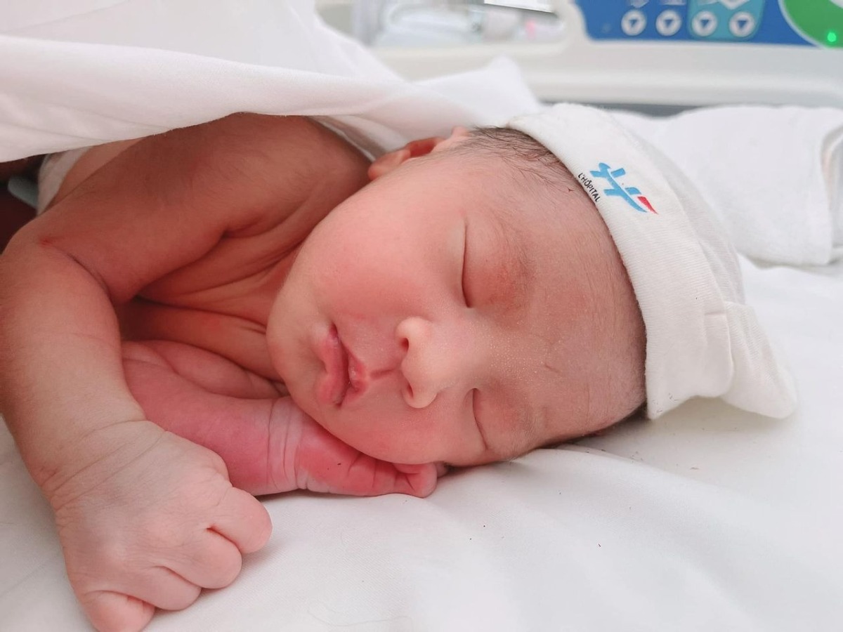 REVIEW ĐI ĐẺ BV VIỆT PHÁP MÙA DỊCH 🤰🏻 

Chào các mẹ ♥️
Sau hơn 1 tháng giờ e mới có thời gian để review lại chuyện đi đẻ mùa dịch của e 😁

1 quá trình đi đẻ cực nhớ đời luôn ạ 😅 E ko giỏi văn lắm nên bài viết có thể hơi lan man nên mong các mẹ thông cảm ạ 😘

✅ E ở Sapa, đăng kí gói sinh mổ ở Việt Pháp lúc 32w. E đặt lịch khám và mổ của bác Thu, e mổ 29/7. E xuống HN trước ngày mổ tầm 3 tuần, vừa tiện đi khám và để nếu có vấn đề gì thì vào viện cho nhanh 😁 
✅ Theo như dự định thì đến tầm 26/7 ck e mới xuống để đưa vk đi mổ. Nhưng đúng đến 23/7 thì HN bắt đầu giãn cách XH. Và e cứ nghĩ sẽ ko làm quá chặt và khó khăn nên e đã ko bảo ck e xuống luôn trước thời điểm ra chỉ thị 😣

Nhưng ko ngờ là lần này HN làm chặt ngay từ ngày đầu tiên, các xe ko thể vào HN dù lí do gì trừ xe luồng xanh, công vụ. Đến lúc đó thực sự lo lắng ko biết làm thế nào để ck e vào HN đưa e đi đẻ. 2 vk ck sốt ruột nghĩ đủ mọi cách, hỏi khắp nơi các đường tránh để vào HN. Cũng gọi điện nhờ viện gửi cho hồ sơ thông tin xác nhận là 29 e mổ để đưa cho ck, khi xuống gặp chốt để giải thích với công an xin được vào HN đưa vk đi mổ. 

Nhưng xong sau nhiều biện pháp thì thấy cái nào cũng rất khó nên đành chấp nhận ck e ko xuống HN để đưa e đi mổ nữa. Mà e sẽ tự đi đẻ 1 mình 😣

✅ Rồi lại phải tính đến chuyện khi e xuất viện thì sẽ về kiểu gì và có về được Sapa hay ko. Vì thời điểm HN bị giãn cách thì tất cả những người từ HN về Lào Cai đều sẽ phải đi cách ly tập trung hết. Người ta có thể ưu tiên cho e là sản phụ về cách ly y tế tại nhà, nhưng tất cả người trong nhà cũng đều sẽ bị cách ly tại nhà theo, và người đưa e về như ck e thì sẽ phải đi cách ly tập trung. Mà nhà e là nhà hàng nên việc về như thế sẽ ảnh hưởng đến quán, phải đóng cửa ko đc bán hàng, vì vậy e quyết định ko về Sapa. 

Lúc đó thì ở Yên Bái làm nhẹ nhàng hơn ( vk ck e là người Yên Bái ), là những người ko phải vùng đỏ của HN về Yên Bái sẽ chỉ phải cách ly y tế tại nhà. Nên vk ck e quyết định về Yên Bái ở nhà mẹ đẻ e, cách ly tại nhà 14 ngày sau đó sẽ lên Sapa sau. 

Ck e phải mang tất cả đồ đạc sử dụng từ Sapa về Yên Bái để chờ đón 3 mẹ con. Và thuê xe cấp cứu ở Yên Bái đến ngày e ra viện đón 3 mẹ con, vì lúc đó chỉ có thuê xe cấp cứu là đi dễ nhất qua các chốt mà ko lằng nhằng các thủ tục. 

✅ Đúng là bsi dặn chiều 28 e qua viện để test covid nhưng vì dịch dã nên e xin bsi sáng sớm 29 e viện test để đỡ phải đi lại nhiều. 
Nên sáng 6h e và e gái ck e ( e gái ck e học dưới HN, vì ck e ko xuống đc nên đưa c đi để có vấn đề gì còn thông báo vs ck e ) đã đến viện để test và chờ kết quả. Đến khi có kết quả thì 2 ce lên tầng 4 khoa sản, lúc đó còn rất sớm nên viện rất vắng. 
Đến ngồi chờ 1 lúc thì 1 cô nữ hộ sinh dẫn e vào phòng đưa đồ dùng cá nhân và dặn tắm rửa sạch sẽ, rồi có y tá đến cắm truyền cho và nằm chờ lúc nào phòng mổ gọi lên thôi.

✅ Chắc đến tầm 8h hơn thì e được đẩy lên phòng mổ. Thấy nhiều mẹ nói phòng mổ của viện đẹp và lạnh lắm mà đẹp thì e công nhận, siêu sạch sẽ. Còn lạnh thì chắc do e ở Sapa nên thấy cũng bình thường ko lạnh lắm 🤣. Các cô y tá cũng hỏi e suốt có lạnh ko mà e ko thấy lạnh gì cả, nhưng vẫn được luồn ống sưởi vào người. Các khâu chuẩn bị trước khi mổ cực kì cẩn thận, e nhìn mãi mà ko thấy bác Thu đâu nên cũng hỏi y tá là bác Thu vẫn mổ cho e chứ ạ 😅. Phải đến khi mọi thứ đc chuẩn bị sẵn sàng thì khi đó bác Thu mới có mặt và ra chào e, lúc đó nghe thấy giọng bác Thu là thấy yên tâm hẳn 😍

✅ Dù có thuốc tê nhưng mọi thao tác e đều cảm nhận rõ ràng và rất nhanh đến 9h05 thì bé nhà e “ oe oe “ 🥰
Y tá đưa bé cho mẹ nhìn rồi đưa đi. Đến đoạn này thì thực sự e vẫn thấy sợ 😂 Vì chắc là bác sĩ ấn ổ bụng để kiểm tra hay như thế nào khiến e cực kì khó chịu, lúc đầu e còn cố chịu nhưng lúc sau thì ko chịu nổi phải bảo bác sĩ dừng lại. Xong e được tiêm thêm thuốc và thở oxy thì dần dần e thiếp đi lúc nào ko hay. Đến khi tỉnh lại mọi thứ gần xong xuôi hết rồi. 😁
Sau đấy e đc đưa đến phòng hậu phẫu để theo dõi và bé nhà e cũng được đưa đến để da kề da vs mẹ ( vì e ko có ck đi cùng nên e xin cho bé da kề da vs mẹ ). 

✅ Sau 2 tiếng thì 2 mẹ con được đẩy về phòng nằm nghỉ. Các cô nữ hộ sinh vào kiểm tra, hỏi thăm liên tục để xem mẹ có đau hay cần gì ko. 9h e rút tiểu và được đưa vào wc để vệ sinh. Đến tầm 11h thì e đã có thể tự đẩy con sang cho các cô trông hộ. 
Đến ngày thứ 3 tháo băng vết mổ là đc đi tắm. Dù đi lại tốt hơn nhưng vẫn có cô nữ hộ sinh vào tắm gội đầu sau đó sấy tóc cho ☺️
Cần bất kì việc gì chỉ cần bấm nút là các cô có mặt rất nhanh 😅 chắc 1 phần vì phòng của e đối diện phòng của các cô (453). Dù ngày hay đêm các cô đều phục vụ cực kì chu đáo.
Đêm thì gửi con cho các cô trông nên mẹ được ngủ 1 mạch đến sáng, sức khoẻ hồi phục nhanh. ( phòng e sát phòng các con nên thường đêm thỉnh thoảng sẽ nghe thấy các con khóc, nên mẹ nào khó ngủ thì ko nên ở phòng này ạ ) 

✅ Nghe mọi người nói là mổ lần 2 sẽ đau hơn rất nhiều, nhất là đau dạ con mà thực sự ngoài việc e thấy đau chỗ 2 bên mạn sườn 1-2 ngày đầu ( chắc do tác động lúc mổ mà bị ấn bụng ) và đau lưng ra thì e ko hề thấy đau vết mổ hay dạ con 1 chút nào cả. Chắc do e hợp thuốc giảm đau của viện 🤣. E có sử dụng giảm đau cơ vuông sau mổ nữa. 

✅ Cơm ở viện thì vừa ngon, mà đa dạng nhiều món để các mẹ lựa chọn. Đầy đủ chất dinh dưỡng chứ ko hề kiêng khem đâu ạ. Đặc biệt các mẹ phải ăn thử món tôm nhé, siêu ngon luôn ý 😉

✅ Phòng ốc cực kì sạch sẽ. Hàng ngày đều đc lau dọn cẩn thận. Chăn ga thay liên tục. Đồ dùng cá nhân cũng đc sắp xếp đầy đủ. 

✅ Đến hôm e xuất viện thì phải test covid lần nữa để về có giấy test qua chốt ở Yên Bái, may nhờ đc cô Lan xong cô nói vs bsi Quyết ( sáng hôm đấy lịch bsi Quyết khám cho e ) chỉ định test covid cho e và bé lớn nhà e. 
Lúc bé lớn nhà e đến viện thì e xuống đón và chờ bé test có kq rồi 2 mẹ con lên phòng, đến khi các thủ tục xuất viện của e xong thì 3 mẹ con xuống sảnh xe cấp cứu đón rồi về thôi ạ. 
3 mẹ con e về đến Yên Bái bình an và cách ly tại nhà đủ 14 ngày sau đó lên Sapa 😍

✅ Vì viện đã có đầy đủ tất cả đồ dùng cho mẹ và bé nên mẹ chỉ cần vác cái bụng bầu đi đẻ thôi nhé 😅.

♥️ Thực sự e muốn gửi lời cảm ơn đến BV Việt Pháp đã cho e 1 trải nghiệm cực kì ưng ý khi sinh mổ tại viện. 
♥️ Cảm ơn bác Thu và ekip mổ đã mổ thành công cho 2 mẹ con e. Dù bác Thu là trưởng khoa, rất bận rộn nhưng cực kì ân cần chu đáo. Trong suốt quá trình khám thai bác đều rất cẩn thận dặn dò tư vấn rất kĩ, vết mổ rất đẹp. Về nhà rồi nhưng bác vẫn nhớ và gửi thêm đơn thuốc cho e. 
♥️ Cảm ơn các cô nữ hộ sinh của khoa sản đã chăm sóc mẹ con tận tình những ngày e nằm viện, dù e cũng ko nhớ đc tên cô nào vì nhiều cô quá 😂
Và cả cô Lan trưởng nữ hộ sinh nữa ạ. Cô cũng rất bận rộn nhưng vẫn tạt qua phòng hỏi thăm, về cô còn tặng thêm đồ, việc gì khó cô cũng bảo yên tâm cô sẽ giúp. Ra viện rồi cô vẫn gọi điện hỏi thăm và dặn dò cần gì cứ gọi cho cô. 😍
♥️♥️ Phải nói là chỉ khi sinh ở Việt Pháp xong thì e cảm thấy cực kì ưng ý với những gì mà e đã kì vọng. Vài năm nữa sinh tiếp e vẫn sẽ lựa chọn Việt Pháp là nơi gửi gắm niềm tin và sức khoẻ của e. 😍

❇️ Về Chi Phí : 
- Gói mổ 32w : 54tr800 ( e đki gói thai sản đc giảm 10% ) 
- 4 lần test covid : 400k/lần - 1tr6
- Phát sinh thêm ngoài gói : ~14tr ( Bé nhà e phải tiêm huyết thanh vgb: 6tr ) 
- Thuốc 2 mẹ con ra viện : 4tr 
Tổng chi phí mổ của e tại viện gần 70tr. E ko có bảo hiểm. Nên mẹ nào có bảo hiểm sẽ đỡ đi đc kha khá tiền ạ 🥰
📌 Các mẹ nào ở tỉnh đang có dự định đi sinh ở Việt Pháp mùa dịch nên thì hãy yên tâm nhé 😍
Các mẹ chỉ cần hỏi kĩ lại ở tỉnh của các mẹ quy định như thế nào về việc từ HN trở về. 
Vì có tỉnh chỉ cần test nhanh, có tỉnh lại PCR. Nhưng quan trọng là có phải đi cách ly tập trung hay ko nữa ạ. 
Còn về việc đi lại để nếu thuận tiện các mẹ của thuê xe cấp cứu như e ý 😂 
Nhưng vì là thai phụ nên có đi xe riêng ra đường hay qua các chốt  cũng ko bị làm khó dễ đâu ạ. Chỉ cần các mẹ cứ mang đầy đủ giấy tờ đi nếu lỡ bị kiểm tra thôi.