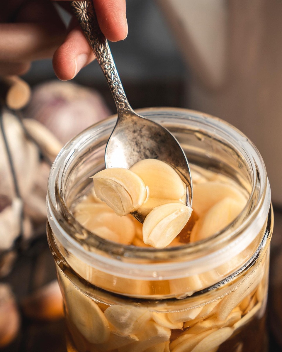 CÁCH LÀM TỎI NGÂM MẬT ONG TĂNG SỨC ĐỀ KHÁNG 🍯

Mình đang được tận hưởng những ngày hạnh phúc khi tuần lễ ẩm nồm đi qua và nắng ấm trở lại. Theo thói quen hàng ngày, mình lấy ra hũ tỏi ngâm mật ong trong bình thủy tinh, pha với nước ấm như trà rồi thưởng thức, trong lòng thấy ấm áp và thư thái vô cùng.

Mình chợt nghĩ, có lẽ ở thời điểm hiện tại, giữ gìn sức khỏe là một trong những vấn đề được người người, nhà nhà quan tâm nhất. Từ lâu mình đã tâm niệm, chính những thứ ta lựa chọn ăn uống, đưa vào cơ thể hàng ngày, chính là yếu tố quan trọng nhất phản ánh sức khỏe. Chẳng phải bạn là những gì bạn ăn hay sao? Hôm nay, mình xin được chia sẻ với các bạn cách làm tỏi ngâm mật ong – bài thuốc dân gian giúp nâng cao sức đề kháng và hỗ trợ phòng trừ nhiều bệnh. Tỏi và mật ong cũng là hai nguyên liệu dễ tìm và rất phổ biến trong căn bếp gia đình Việt Nam. Cùng làm thử ngay bạn nhé!

• Nguyên liệu:
150g tỏi to (khoảng 4 củ)
1l mật ong nguyên chất

• Cách làm:
Tỏi rửa sạch rồi mới bóc vỏ, hoạc bóc vỏ và giữ sạch không rửa lại nước.
Thái lát dọc dày khỏng 2mm.
Cho tỏi vào lọ thuỷ tinh sạch đã tiệt trùng, khô ráo.
Để tỏi nghỉ 15 -30 phút. Có thể vài phút lại xóc đều tỏi lên 1 lần.
rót đầy mật ong cho ngập.
Đậy thật kín để nơi thoáng mát, bọc kín tránh ánh sáng.
Để hết hẳn mùi tỏi thì tốt nhất sau 15 ngày bắt đầu dùng.
Nếu bảo quản tốt, kín sẽ để được rất lâu ở nhiệt độ phòng (mùa hè nên để ngăn mát tủ lạnh các bạn nhé).

Nguồn: Esheep Kitchen