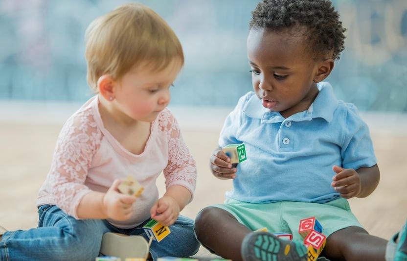 DỪNG VIỆC ÉP TRẺ NHƯỜNG & BÀI HỌC VỀ SỰ CHỜ ĐỢI
Không ít cha mẹ rơi vào tình huống khó xử khi 2 đứa trẻ đang chơi, mà có 1 bé đòi chơi đồ chơi của bé còn lại, nhưng bé kia lại không chịu mà bé đòi lại khăng khăng đòi bằng được. Vậy, nếu bạn gặp tình huống này, bạn sẽ chọn cách nào sau đây để dàn xếp:
1. Nói bé lớn hơn: "thôi con nhường em nhé" và lấy đồ chơi cho bé nhỏ hơn.

2. Dụ lấy món đồ chơi của bé này để cho bé kia và cho bé này 1 món đồ chơi khác.

3.Cất món đồ chơi và không cho bé nào được chơi, để 2 bé quên và chơi món khác.

4. Nói với bé đang đòi là không được, đồ chơi là của bé này, yêu cầu phải chọn món khác.

Phần lớn cha mẹ chúng ta sẽ chọn 1 trong 4 cách trên, nhưng thực tế rằng: cả 4 cách trên trẻ vẫn không hiểu vai trò thực của trẻ trong tình huống này, vấn đề có thể được dàn xếp tạm thời, nhưng vẫn tiếp diễn và trẻ vẫn không nhận được bài học giáo dục về "tương tác hành vi".

KHÁI NIỆM NHƯỜNG/CHIA SẺ Ở TRẺ LÀ ZERO NẾU BẠN KHÔNG DẠY.
Mọi đứa trẻ chưa nhận thức được sự tồn tại của khái niệm nhường hay chia sẻ tình thương, đồ vật, khoảnh khắc hay món đồ trẻ yêu thích. Đây là hành vi học được. Do đó, việc bạn cố ép hoặc cố năn nỉ kiểu như " Thôi nhường em/bạn đi con, mẹ mua/ lấy cái khác cho con nhé!" là không ý nghĩa với trẻ. Hơn nữa, dù bạn có giải thích "cái này là của bạn, con có thể chọn cái khác" cũng không thể làm trẻ hiểu.

Với trẻ, những thứ tồn tại tại thời điểm trẻ đang chơi/thưởng thức là được đánh dấu là "hiện diện". Sự hiện diện này sẽ đi kèm với cảm xúc trẻ có như vui, lạ, hạnh phúc. Nếu sự hiện diện này mất đi, trẻ cần phải đi tìm. Nếu hiện diện nằm ở trẻ khác thì trẻ sẽ lấy lại. Tuy nhiên, sự hiện diện luôn có tính tạm thời.
Sự hiện diện ở đây có thể là món đồ chơi trẻ đang chơi, là khoảnh khắc được bạn yêu thương, là 1 trò chơi nào trẻ đang tham gia. Khi đó, việc 1 trẻ khác hoặc em của trẻ lấy đi sự hiện diện này thì việc trẻ đi tìm hoặc dành lại là điều dễ hiểu.

LÀM SAO DẠY TRẺ SỰ CHIA SẺ, KHÔNG PHẢI ÉP TRẺ CHIA SẺ
Sự chia sẻ là sự luân chuyển của sự hiện diện giữa 2 bé đến khi trẻ nhận ra là không mất đi. Dĩ nhiên, khi đó cảm xúc sẽ đi theo sự hiện diện đó ở cả hai bé. Càng nhiều sự chia sẻ thì trẻ càng học được hành vi biết chia sẻ. Khi trẻ học được hành vi biết chia sẻ thì trẻ sẽ hiểu sự cảm thông. Khi đó, trẻ luôn có sự cảm thông. Đó là cách giáo dục.

Ngược lại, sự ép trẻ nhường là cách buộc trẻ từ bỏ "sự hiện diện" và cảm xúc cũng mất theo. Sự hiện diện chỉ tồn tại ở 1 trong hai bé, và cảm xúc cũng chỉ có ở 1 trong hai bé. Giống như cách bạn hay nói "con lớn rồi nhường em nhé con!", thực tế, trẻ không chỉ không hiểu khái niệm nhường này, mà còn có thể mang 1 cảm xúc tiêu cực khác như buồn/hụt hẫng khi sự hiện diện mất đi, thay vì vui thích trước đó. Đó là cách không giáo dục.

Vậy, để giáo dục trẻ sự chia sẻ, cha mẹ nên làm gì với tình huống được đặt ra ban đầu? Cách tốt nhất được khuyên không phải là 1 trong 4 cách ở trên bởi vì không cách nào giúp cả hai bé nhận ra sự chia sẻ khi cần có đồng thời cả sự hiện diện và cảm xúc gắn liền. Theo GS. Byron T. , ĐH University College London chia sẻ: Bạn có thể giúp trẻ học được sự chia sẻ khi bạn chọn thời điểm vào cuộc thông minh-khi 2 bé chỉ mới bắt đầu có tranh cãi về sự hiện diện. Đừng vào sớm quá và cũng đừng đợi 2 bé cắn/đánh nhau đến khóc bởi vì khi đó có cảm xúc khác xen vào thay vì chỉ có cảm xúc thích sự hiện diện.

Sau đó, hãy bắt đầu với bài học về "cách đợi". Nghĩa là, bạn nói lớn: Nào, hai con im lặng nào, chúng ta chơi cái này cùng nhau được không. Bạn nói bé đang cầm món đồ chơi: Tom, con đưa món đồ chơi sang tay mẹ nhé! Bạn dùng hai tay nhận món đồ từ tay bé và nói: "Được rồi, mẹ nhận món đồ của con rồi nhé, mẹ đang cầm đây, con có thấy không, con có thể sờ nó bây giờ". Bạn quay sang bé đòi món đồ chơi và nói "Tim, mẹ đưa con cầm món đồ này nhé! con đưa 2 tay ra nào", bạn dùng hai tay đặt món đồ vào tay Tim và nói: 'được rồi, món đồ ở tay Tim rồi, mẹ sờ nó nhé, Tom con sờ nó không?". Sau đó, bạn nói "Tom, con nhận món đồ nhé, Tim ơi con dùng 2 tay đưa món đồ cho Tom giúp mẹ nhé!". Khi Tom nhận món đồ, bạn nói tiếp "Mẹ có thể sờ nó và Tim con có muốn sờ nó không?". Thế, là bạn cứ lập lại 1-3 lần nữa. Đó là bài học về "cách đợi". Bài học này có thể áp dụng bất kì lúc nào có mâu thuẫn. Trong lúc áp dụng, có bé nào dành, thì bạn lại lấy lại và giữ để cho 2 bé cùng chạm.

Bài học về "cách đợi" này cũng có thể dạy trẻ trong những sinh hoạt đời sống hằng ngày như đi siêu thị, nhà sách. Khi trẻ chạy đến quầy đồ chơi và có bạn cầm món đồ chơi trẻ muốn, hãy nói: "Tim này, đợi 1 tí con!" hãy cho trẻ thời gian đợi, lúc đợi, sự hiện diện và cảm xúc gắn liền vẫn không mất đi. Khi ra tính tiền, bạn cũng xếp hàng đợi đến lượt và không quên nói trẻ "chúng ta đợi 1 chút để đến lượt nhé!"

Càng học được bài học về biết chờ đợi, trẻ càng nhận ra sự chia sẻ là không mất đi. Dĩ nhiên, cảm xúc hạnh phúc cũng không mất đi khi chia sẻ, chỉ là "đợi" cho đến lượt. Việc này sẽ giúp ích cho trẻ rất nhiều về bài học vị tha và nhân ái.
Note:
Tanya Byron (2008) Your todder month by month. Dorling Kindersley. London.
Jill Ceder (2018) Why You Shouldn't Force Your Kid to Share. Verywell Family.