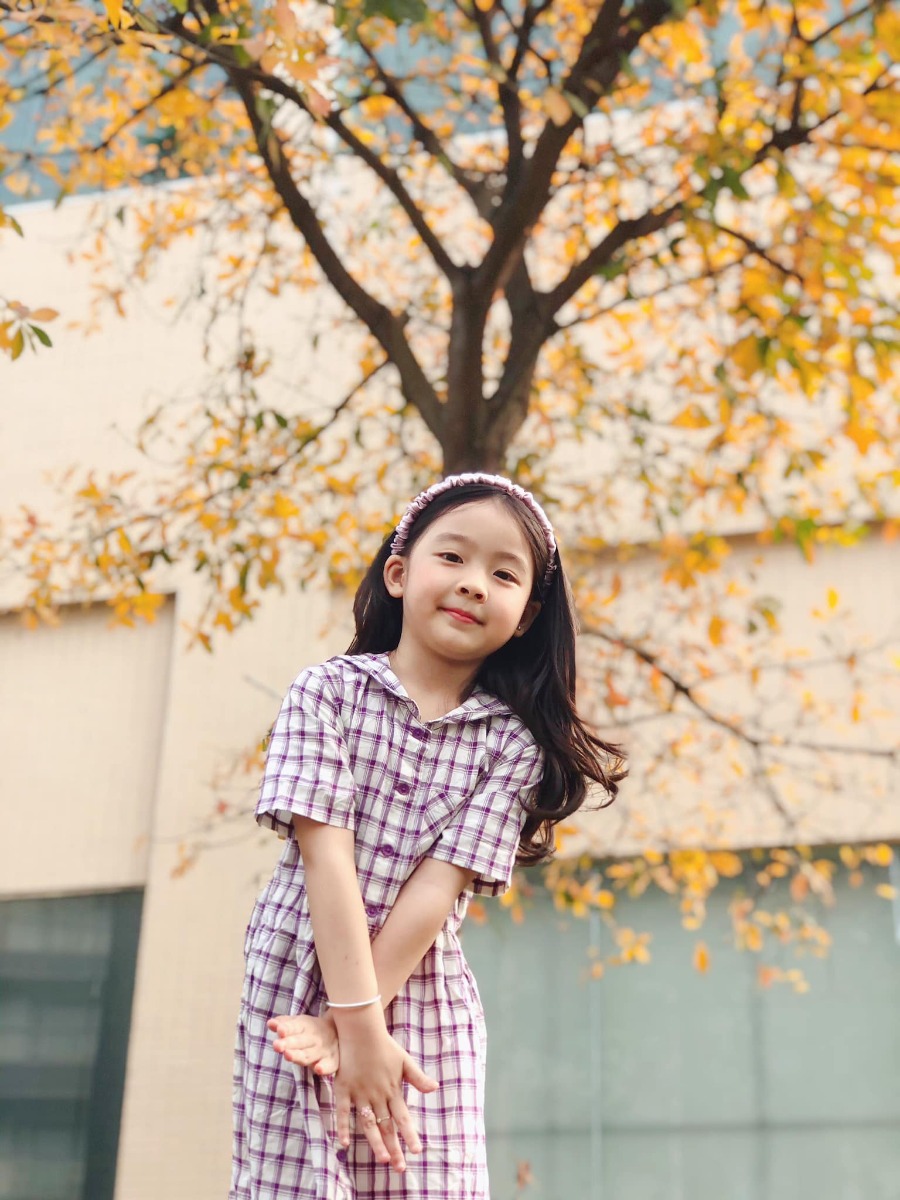 Chào các cô chú, lại là em bé đây ạ. Bữa nay em bé lên công ty mẹ chơi, gặp cây lộc vừng yêu quá nên làm ngay bộ ảnh Hàn Quốc giữa lòng thị trấn nhỏ ạ.
Điện thoại mẹ em bé không hịn lắm nên ảnh hơi kém chất lượng ạ.
Xin phép trình bày quy trình chụp ảnh cho mẫu nhí ạ:
Bước 1: Chọn trang phục và phụ kiện hợp tone màu với cảnh (như bộ này là mẫu mặc sẵn vậy lên công ty mẹ cháu nên cũng không có chuẩn bị trước, nhưng mẹ cháu nhanh mắt nhanh tay kiếm ngay quyển sách tim tím hoa sim mang ra cho đồng bộ).
Bước 2: Ngon ngọt dùng lời động viên, tạo tâm lý thoải mái cho mẫu (có thể tỏ ra đau khổ khi mẫu không hợp tác, tuyệt đối không doạ dẫm). Trêu mẫu, nói chuyện với mẫu tưng bừng lên để bắt khoảnh khắc tự nhiên.
Bước 3: Photographer nằm ngửa ra (dạ, mẹ cháu không nói đùa, chính xác là nằm ngửa ra bãi cỏ chụp từ dưới lên đó ạ vì cái tán cây nó cao lắm).
Bước 4: Mở điện thoại chế độ chân dung, căn cho máy nhận diện và khoá chủ thể (có chữ “ánh sáng tự nhiên “ màu vàng hiện ra là ok) rồi chụp lấy chụp để.
Bước 5: Tải app Meitu, vào phần chỉnh sửa kéo độ sáng, màu sắc lên một xíu, vào filter chọn màu theo tổ tiên mách bảo, không có công thức cố định nào cả, vừa mắt là được thôi. Lưu ý là có thể chồng 1,2,3 filter cho đạt màu ưng ý, có thể crop bớt hoặc xoay cho ảnh cân đối, sau đó vào chỉnh sửa kéo phần “chi tiết” lên (để tăng độ nét).